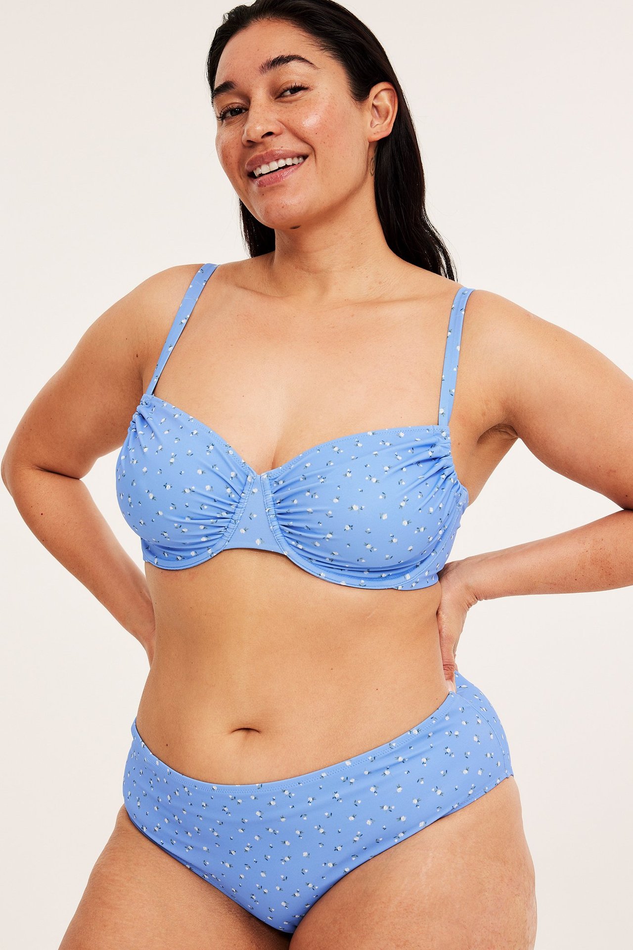 Forfra, kvinne i blåmønstret bikinitruse med normal midjehøyde og matchende bøyle-bikinitopp.