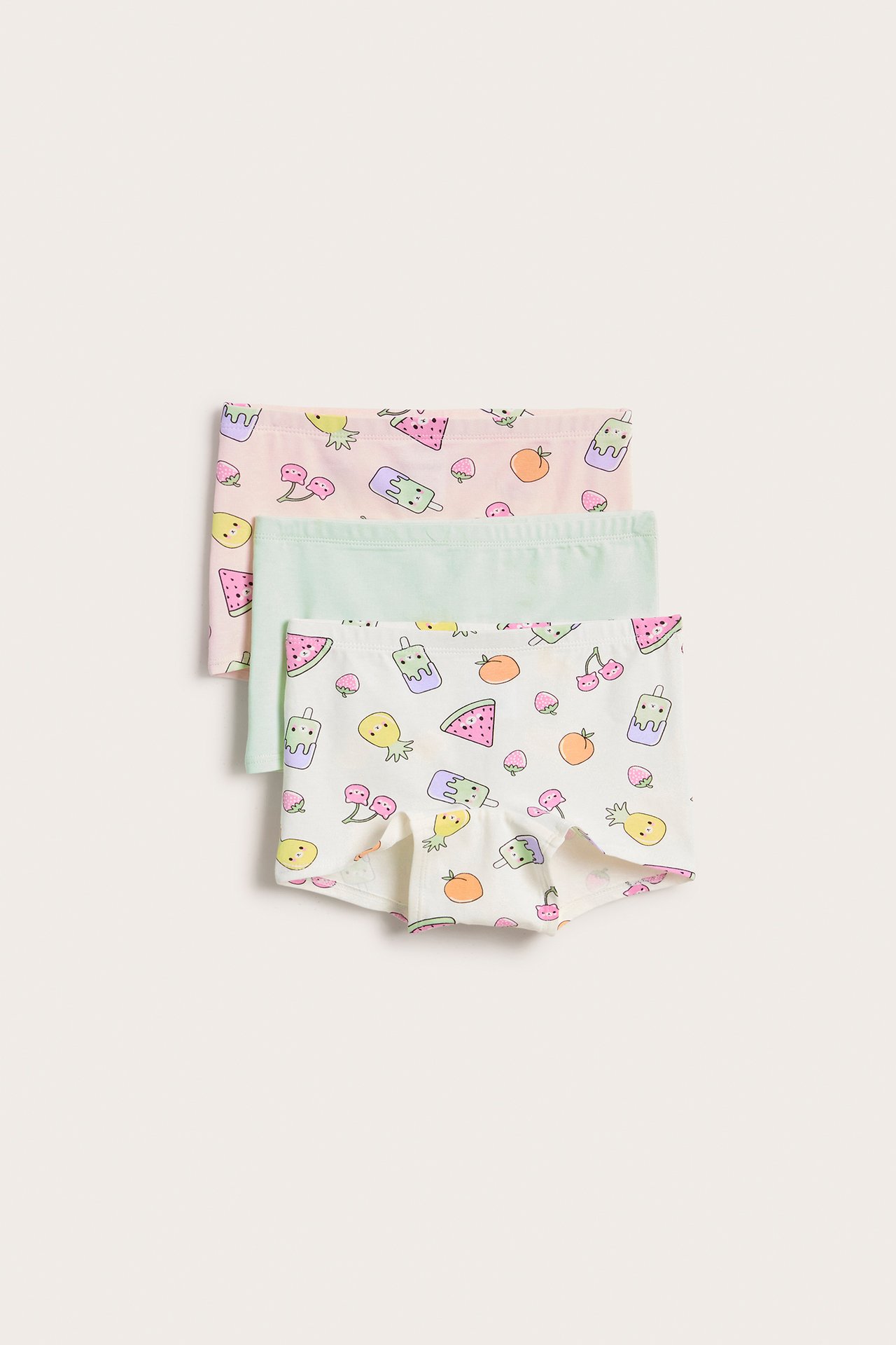 Frontvisning, 3-pakning boksershorts for barn: en mønstret offwhite, en mønstret lys rosa, en ensfarget lys grønn.