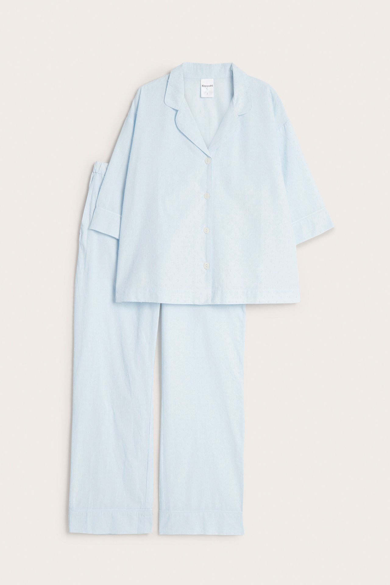 Edestä näkymä vaaleansinisestä kuviollisesta puuvillapyjamasta, jossa on lyhythihainen paita ja pitkät housut.