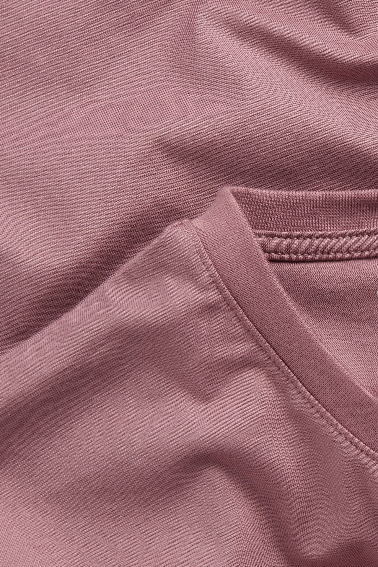 Zbliżenie na męski, ciemnoróżowy, jednokolorowy, bawełniany T-shirt z okrągłym dekoltem.