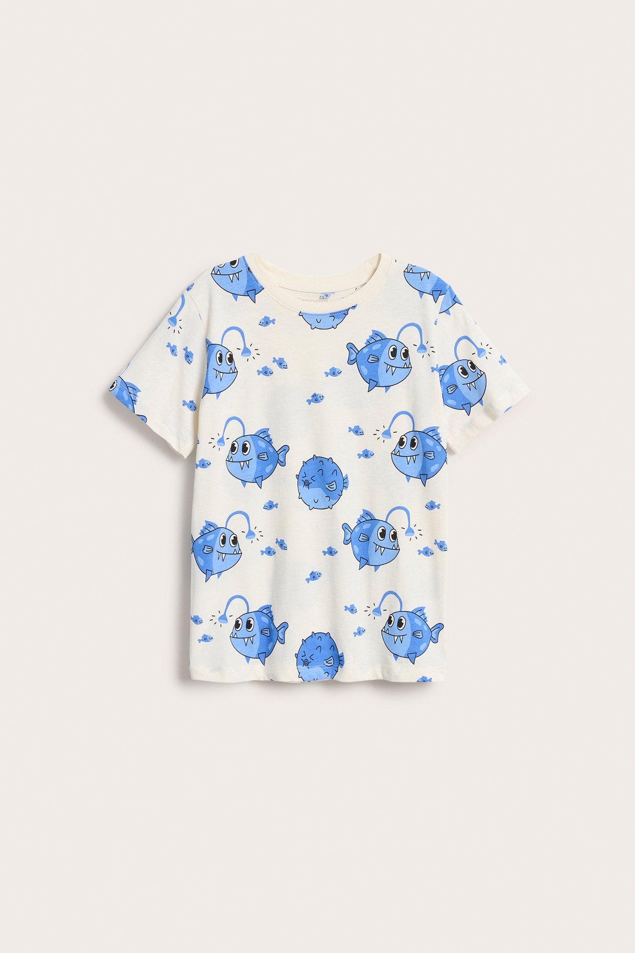 Framifrån, en offwhite t-shirt i bomull för barn med heltäckande blått fiskmönster.