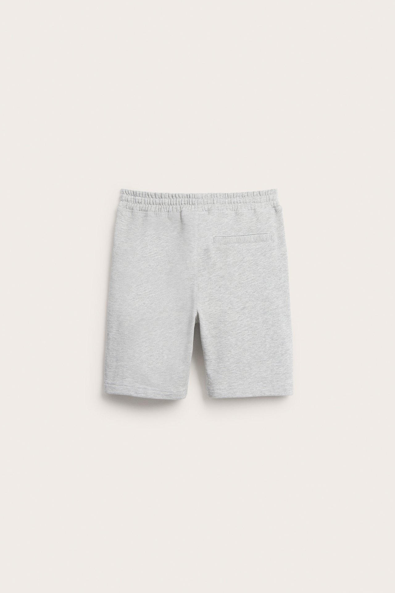 Bakifrån: Ljusgrå enfärgade mjukisshorts med resår i midjan och en bakficka.