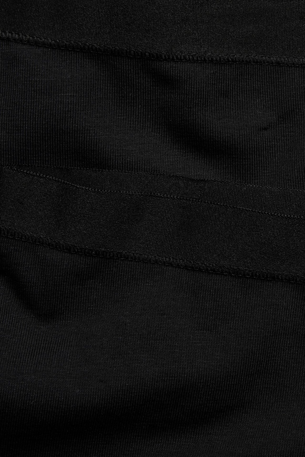 Zbliżenie czarnych, prążkowanych szortów bawełnianych z widocznymi szwami.