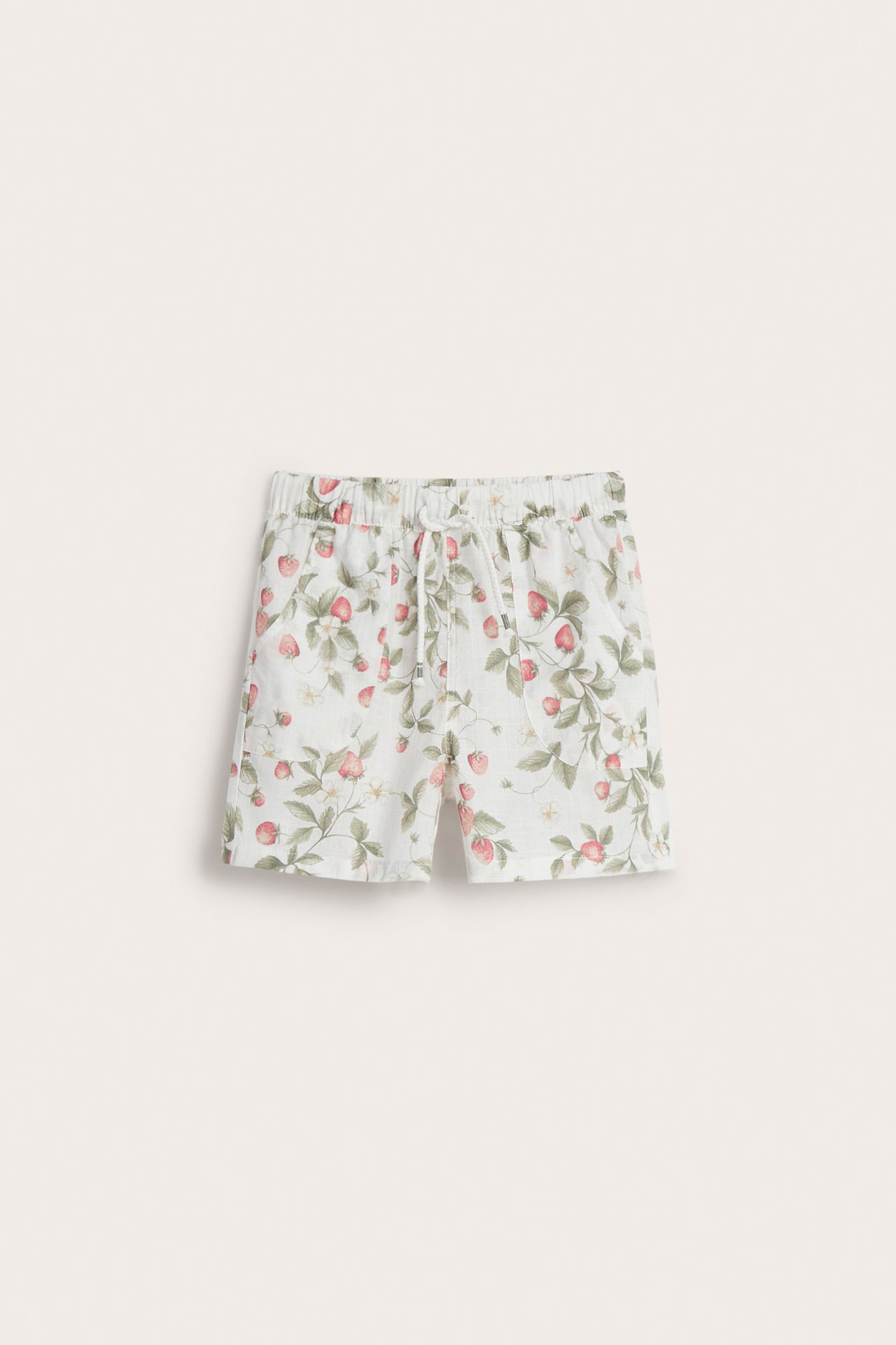 Frontvy av offwhite bomullsshorts med rött jordgubbsmönster, resår i midjan och dragsko.