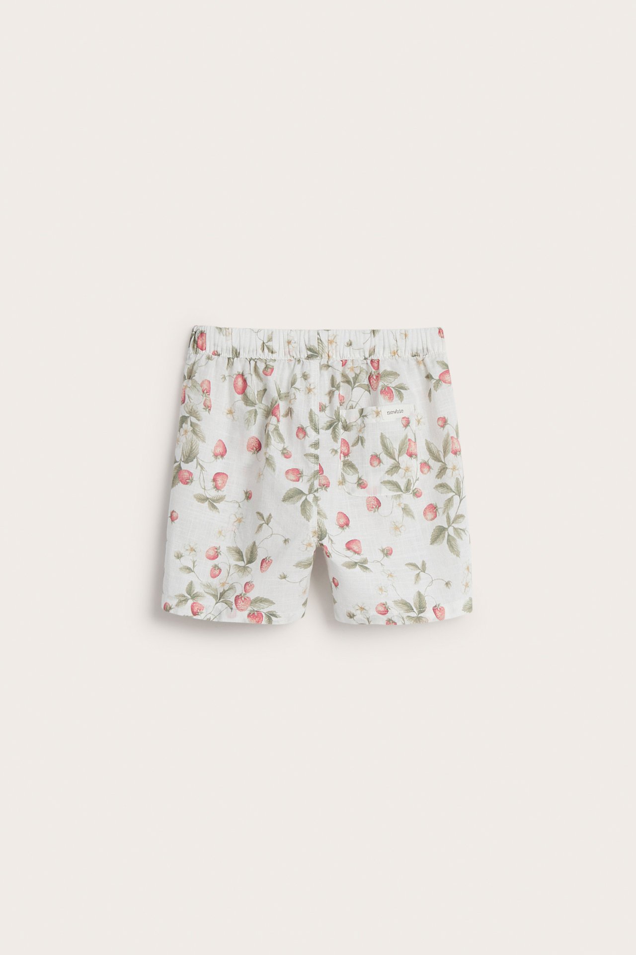 Framifrån: Offwhite bomullsshorts med rött jordgubbsmönster, resår i midjan och dekorativ dragsko.