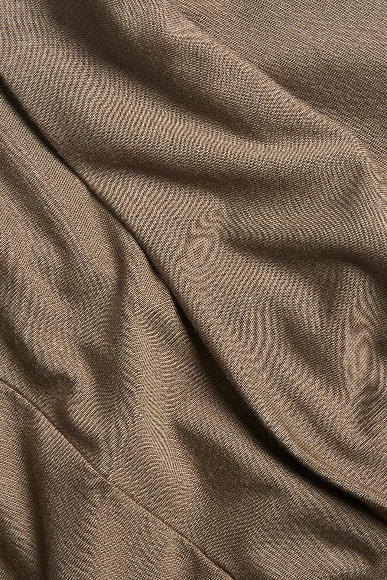 Zbliżenie na brązowy, jednolity materiał dzianinowy z wiskozy na legginsy z miękkimi fałdami.