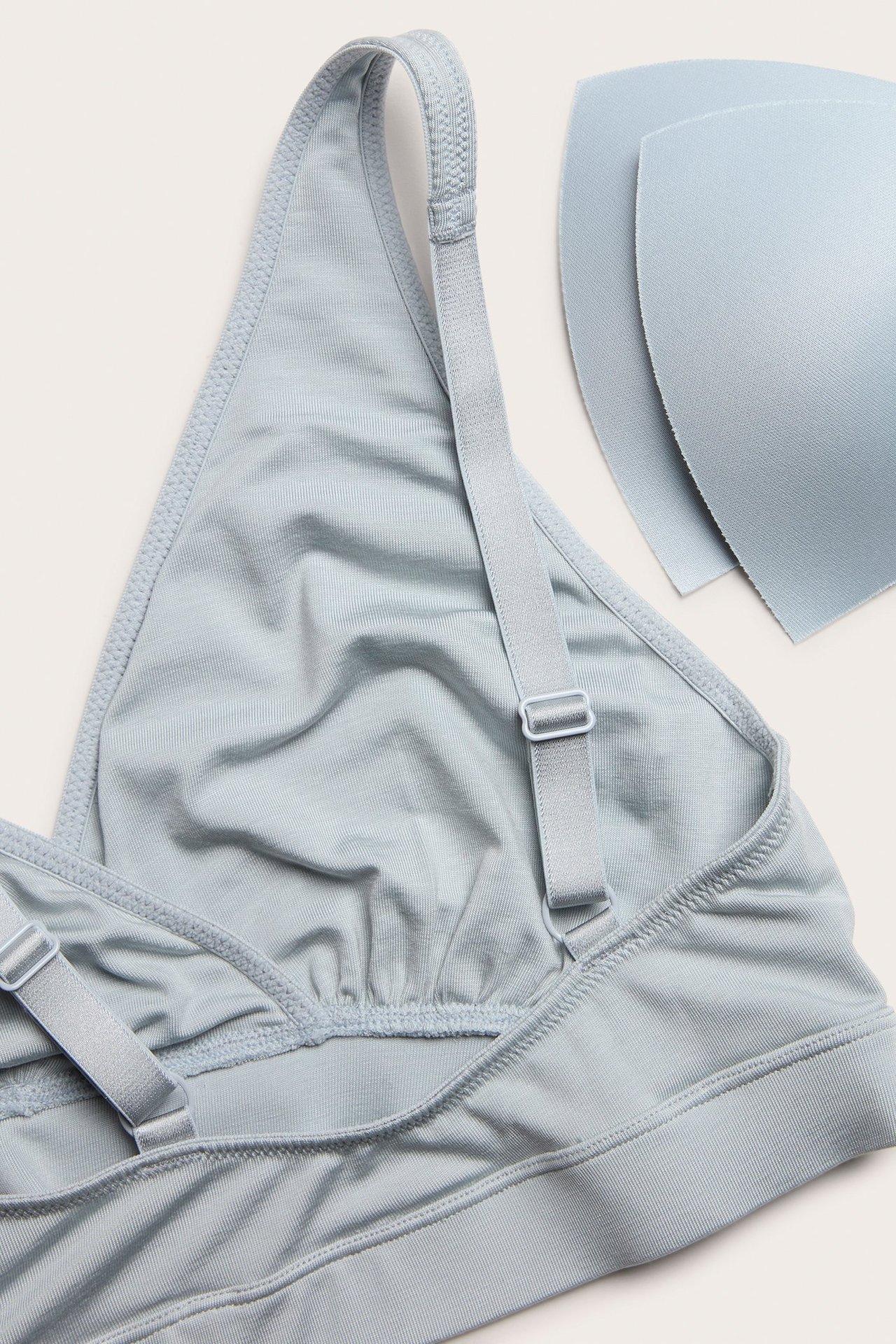 Zbliżenie jasnoniebieskiego miękkiego biustonosza z regulowanymi ramiączkami i dwoma wyjmowanymi wkładkami.