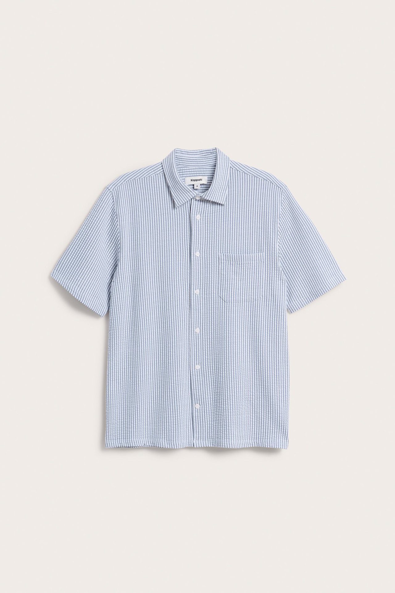 Edestä, miesten tummansinivalkoraidallinen lyhythihainen trikoopaita rintataskulla.