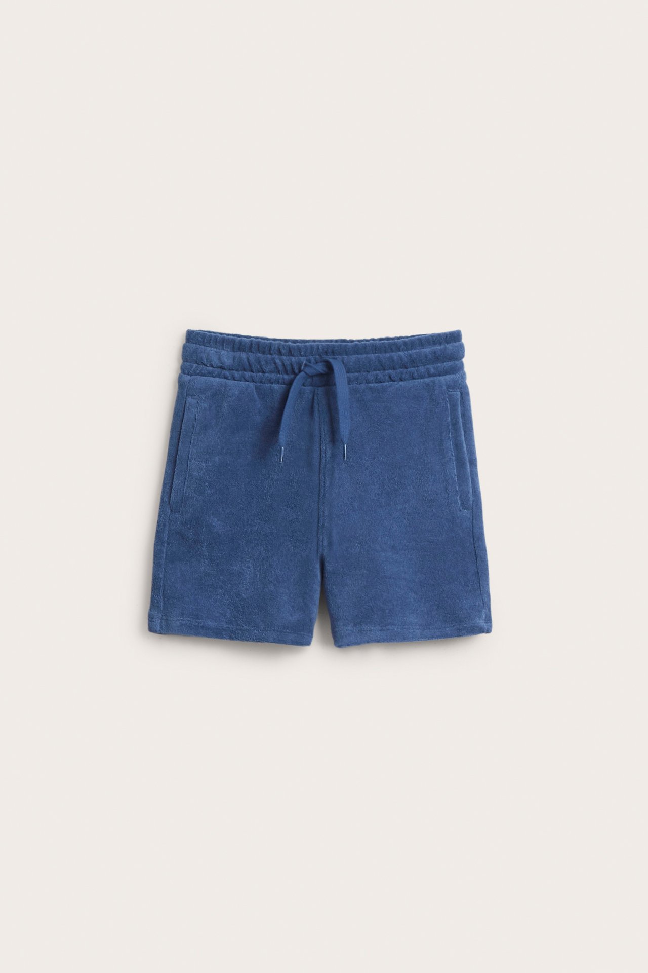 Frontvisning av mørkeblå frottéshorts med elastisk midje, snøring og sidelommer.