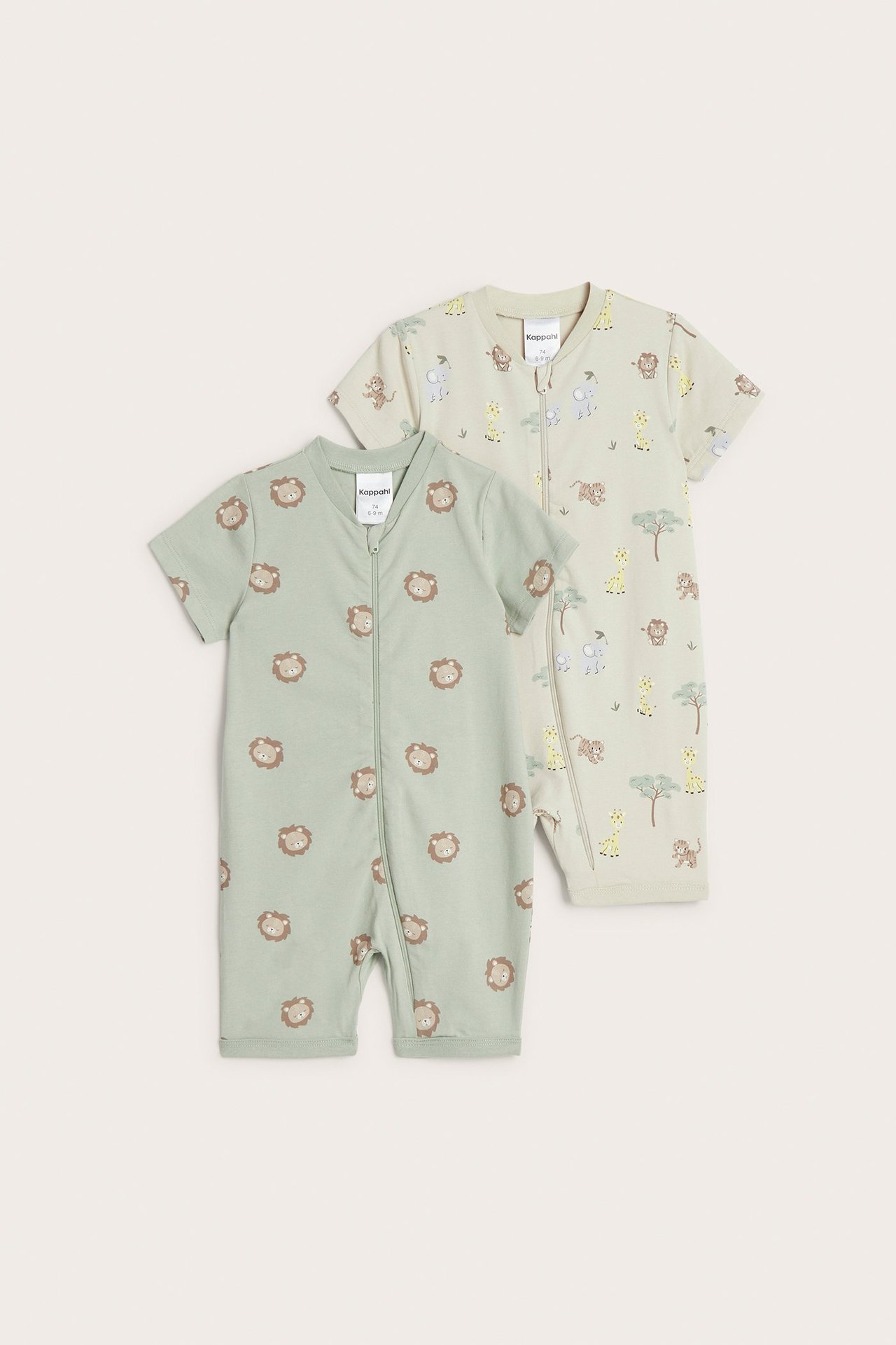 Widok z przodu dwóch krótkich kombinezonów niemowlęcych: zielony z lwem, jasnobeżowy z safari, oba z zamkiem.