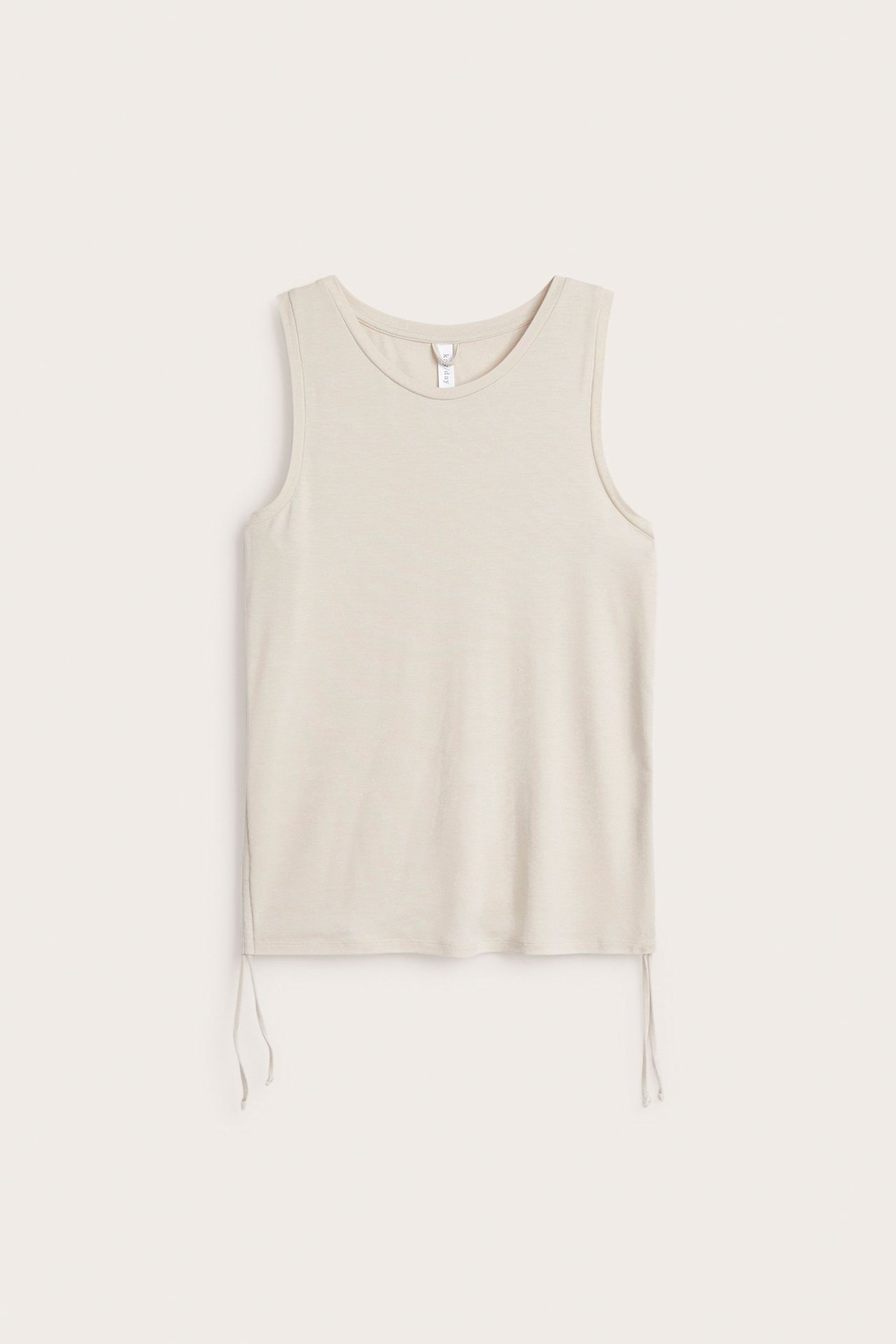 Frontvisning av en lys beige tencel-blanding singlet med snøring i sidene.