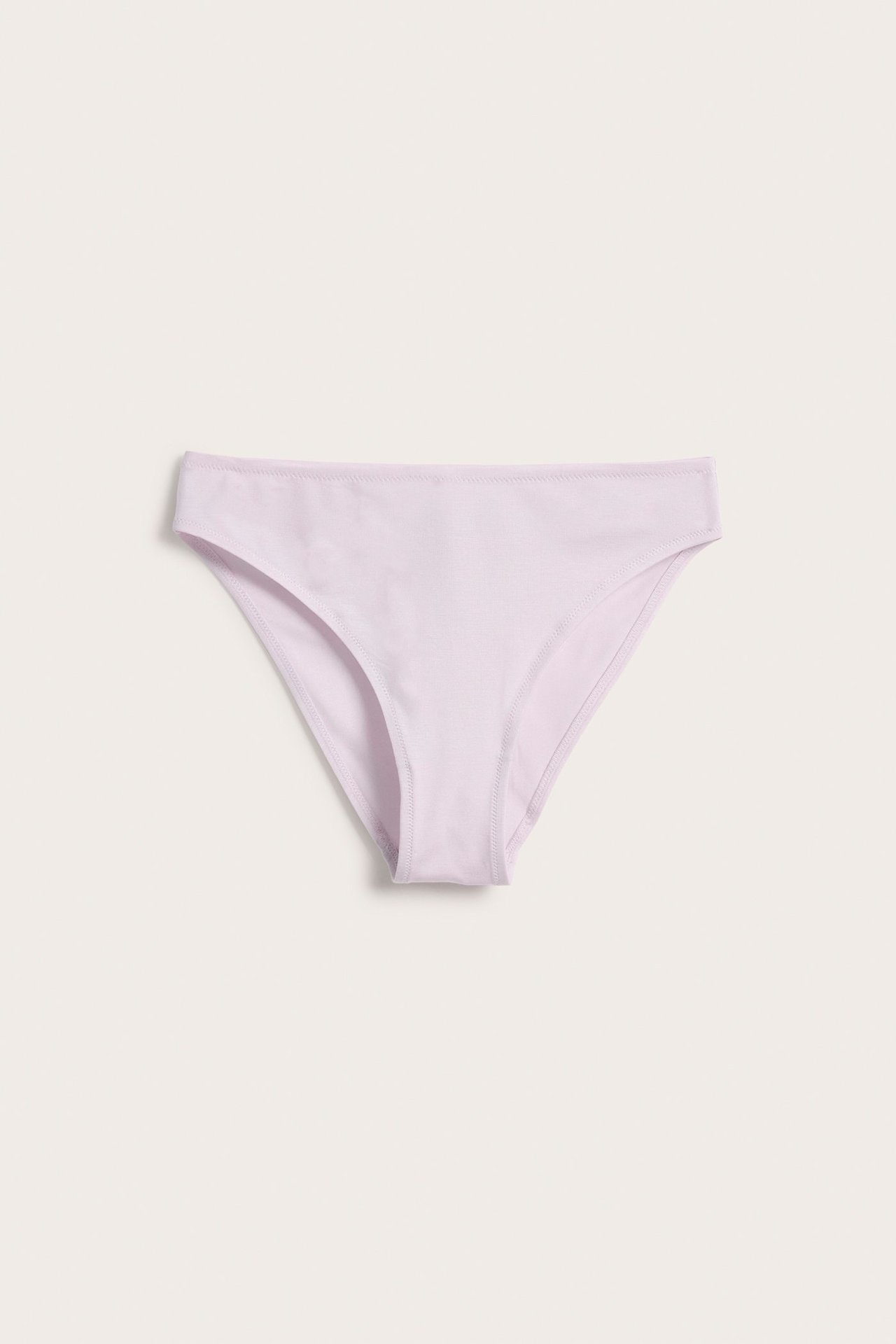 Forfra, lys rosa Brazilian truse i myk Lyocell-blanding, med midi-høyde og ensfarget design.