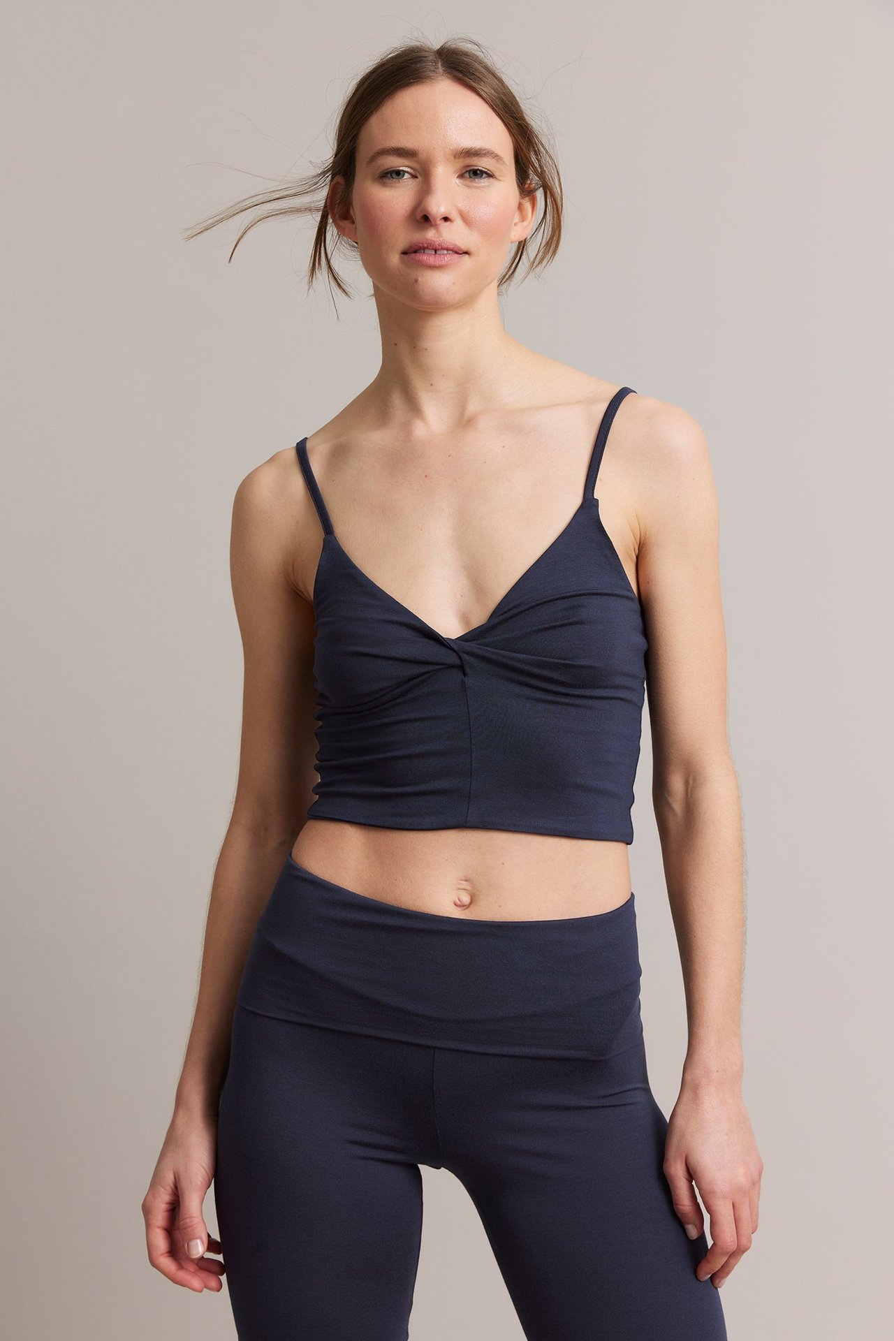 Frontalvisning: Kvinne i mørkeblå viskose loungetopp med vridd detalj og matchende leggings.