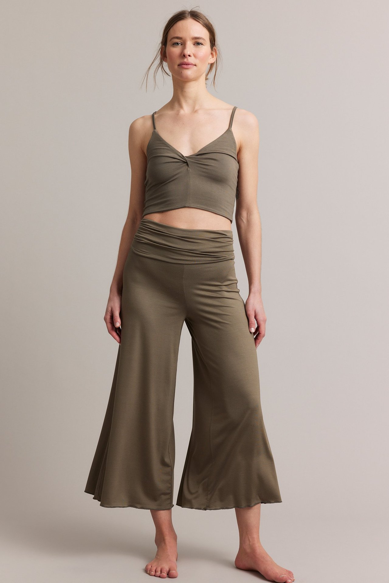 Frontbilde av kvinne i brun viskoseblanding loungetopp med vridd detalj og matchende vide bukser.