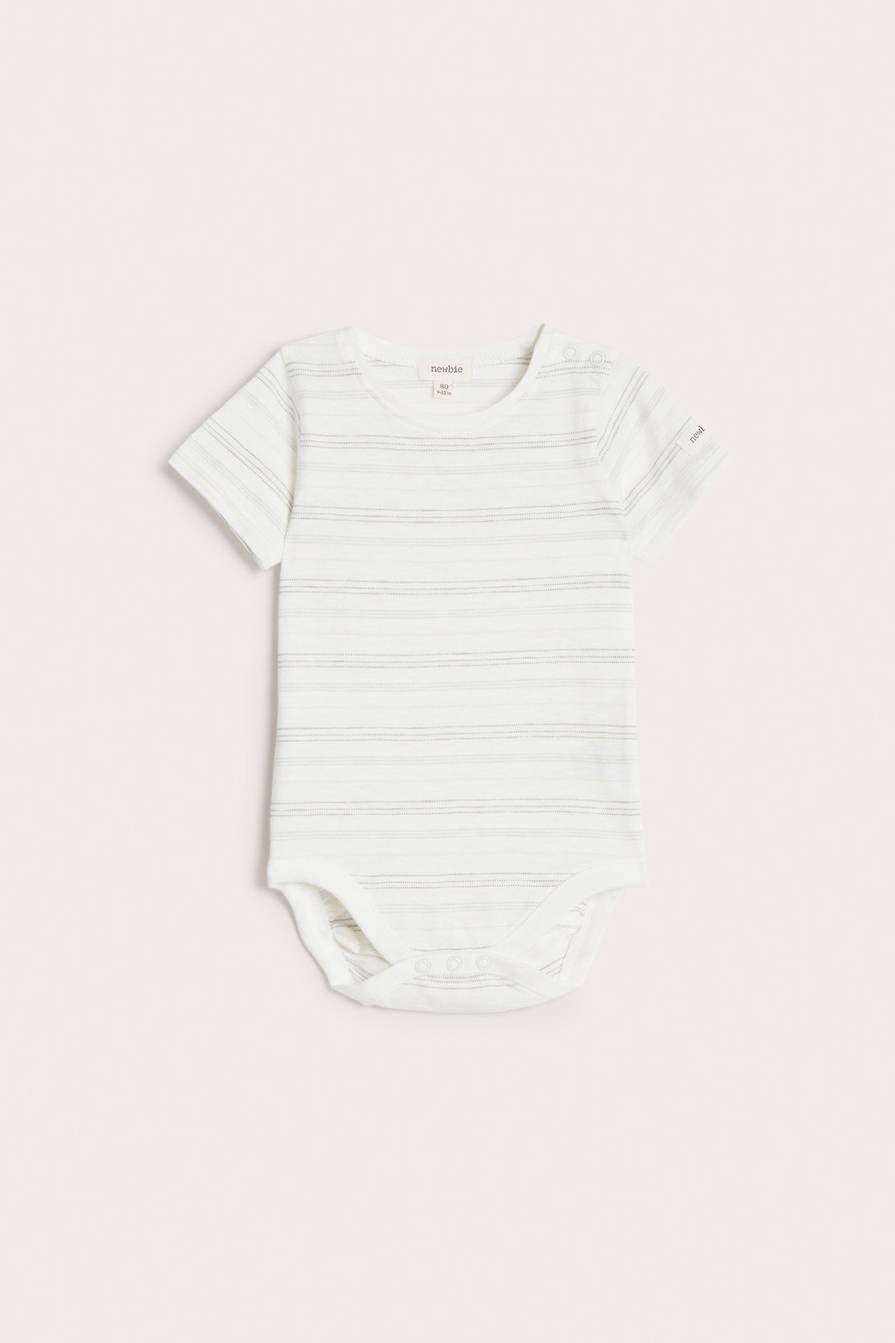 Frontvy av en offwhite randig kortärmad babybody med tryckknappar på axel och i grenen.