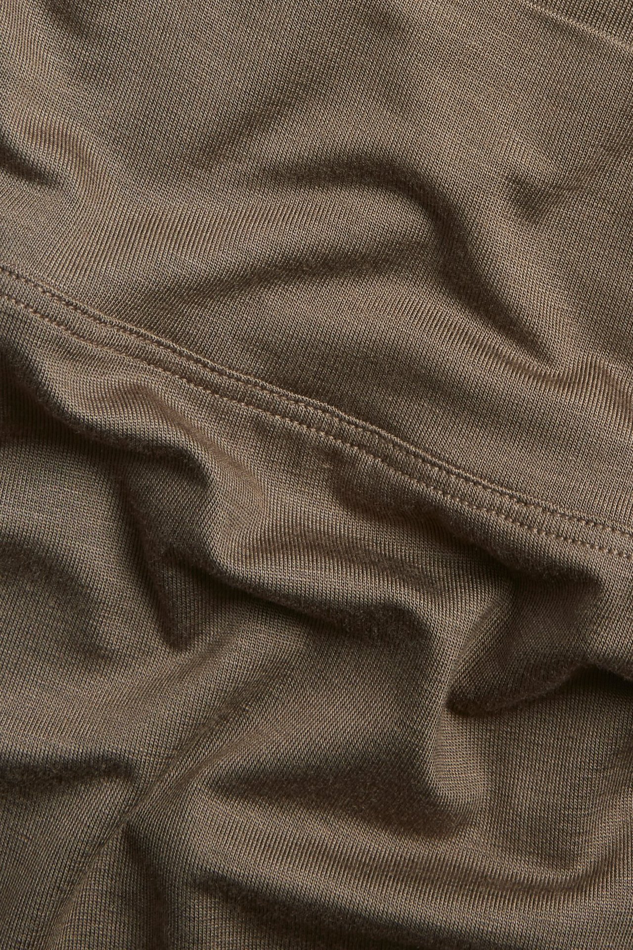 Zbliżenie na brązowy materiał bokserek z mieszanki wiskozy z widocznymi szwami.