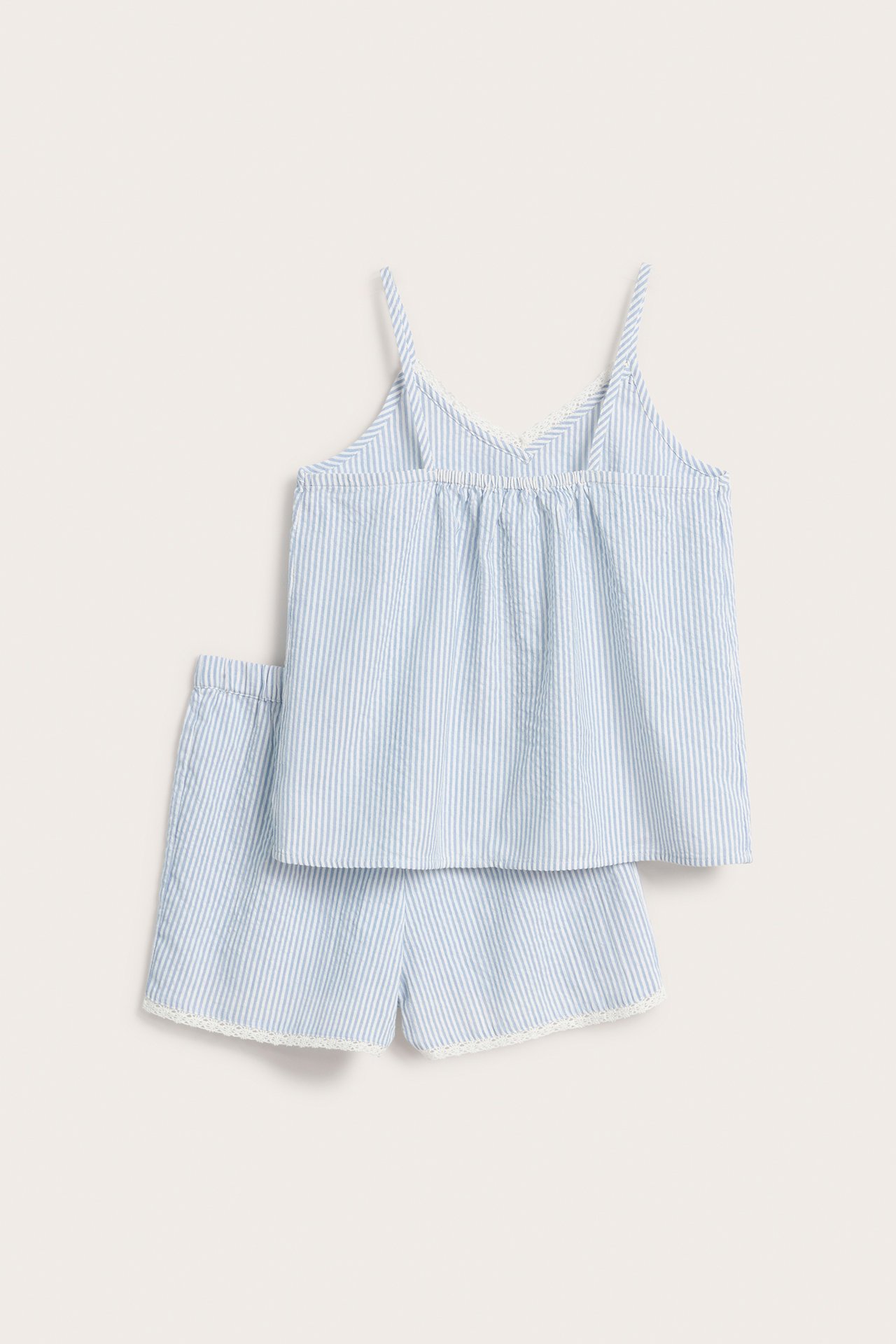 Framifrån: Randig pyjamas i ljusblå bomull för barn, med linne och shorts med vit spetskant.