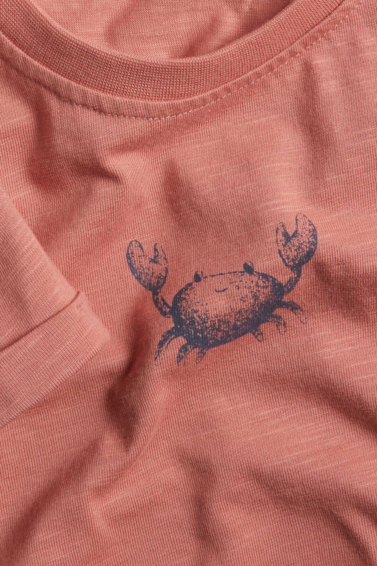 Zbliżenie przód: różowy bawełniany T-shirt z dżerseju slub z granatowym nadrukiem kraba.