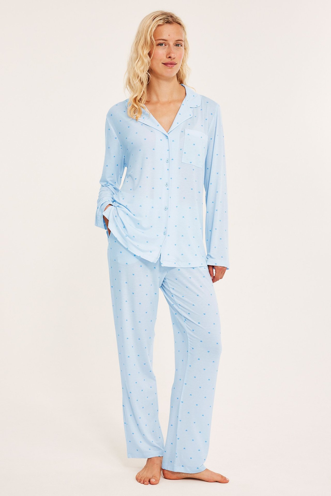 Edestä: nainen yllään vaaleansininen lyocell-pyjama pienellä sydänkuviolla.