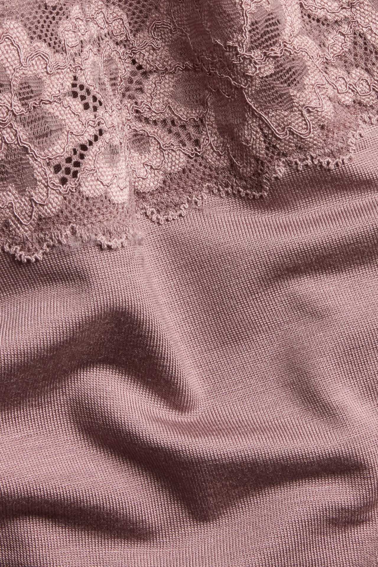 Zbliżenie na ciemnoróżowe prążkowane figi Brazilian z lyocellu z ozdobną koronkową lamówką.