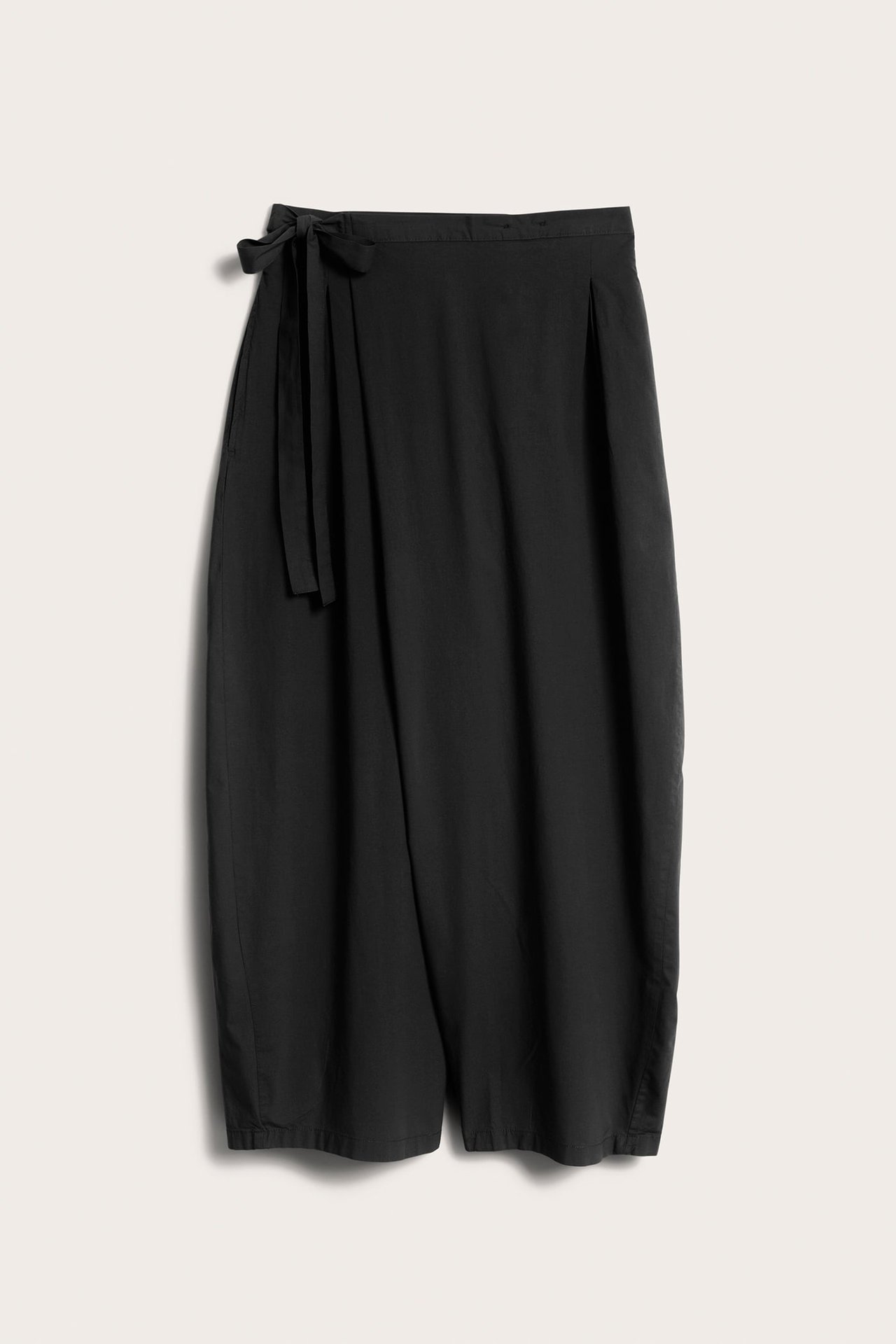 Edestä mustat leveälahkeiset kietaisuhousut popliinikankaasta, vyötärönapilla ja solmimisnauhoilla.