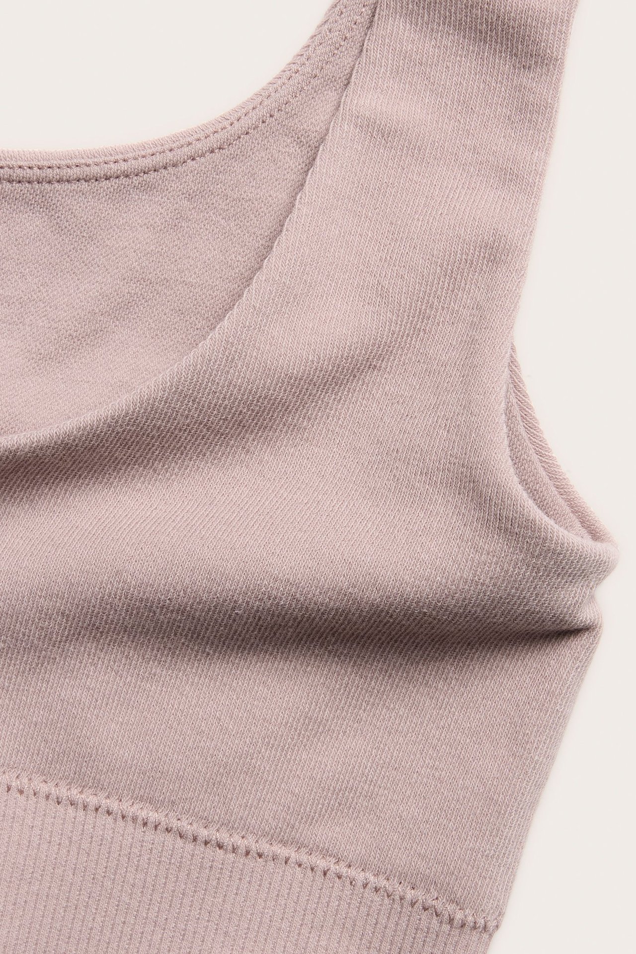 Zbliżenie różowego melanżowego topu biustonosza z mieszanki bawełny z prążkowanym dołem.