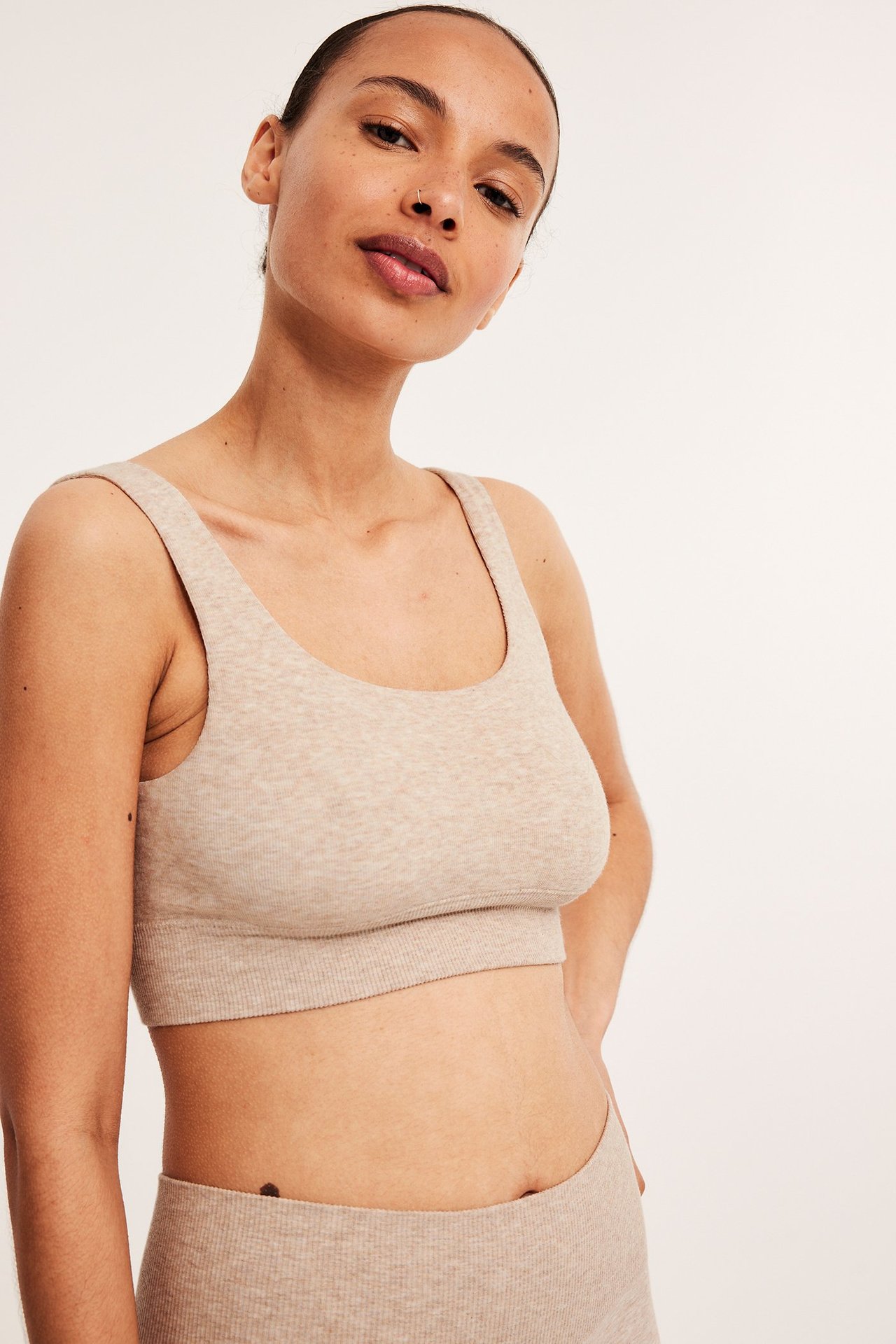 Framifrån, kvinna i beige melerad ribbad bh-topp i bomullsmix och matchande underdel.