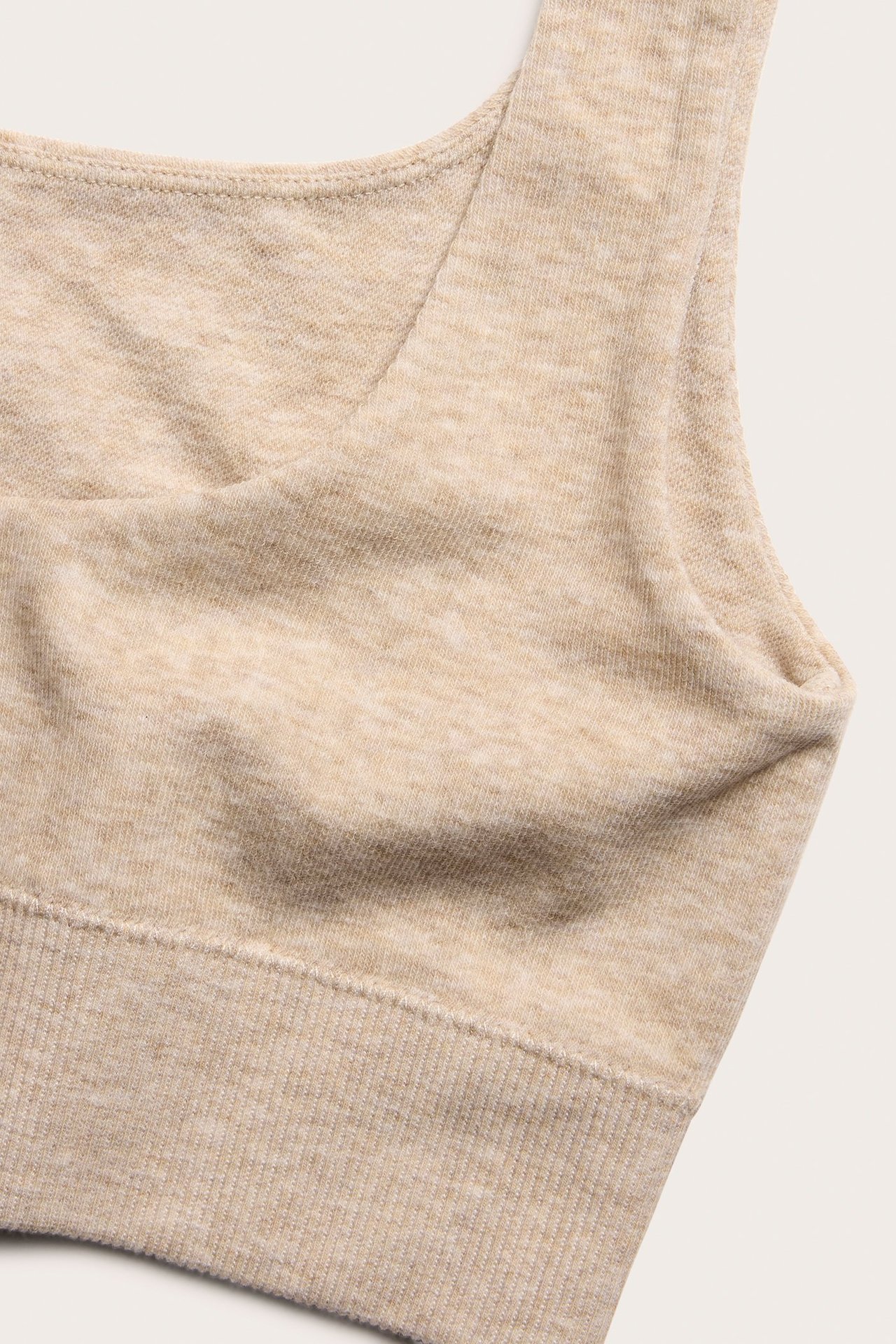 Zbliżenie beżowego melanżowego topu biustonosza z mieszanki bawełny z prążkowanym dołem.