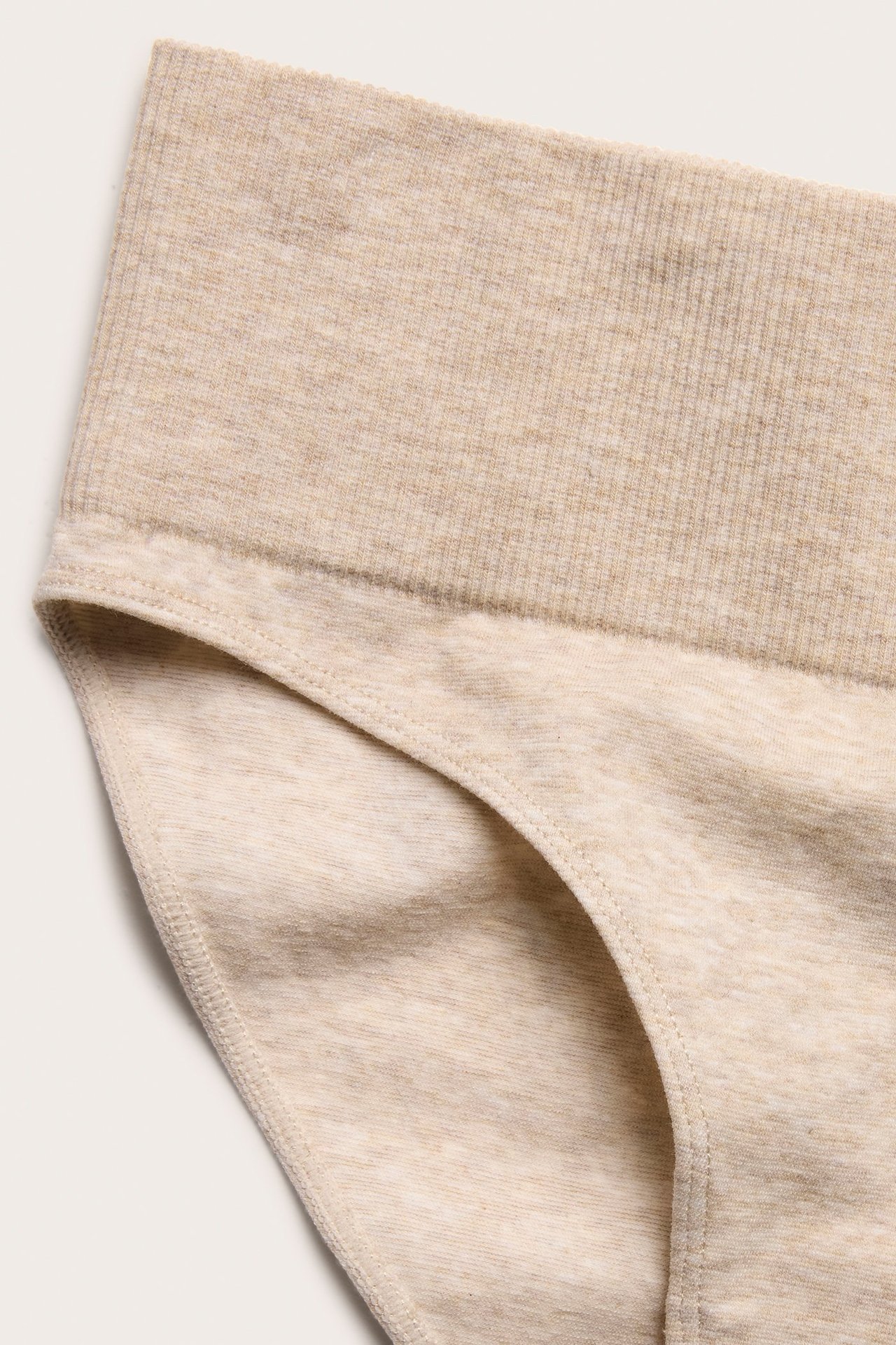 Zbliżenie beżowych melanżowych bezszwowych fig Brazilian z prążkowanym pasem.