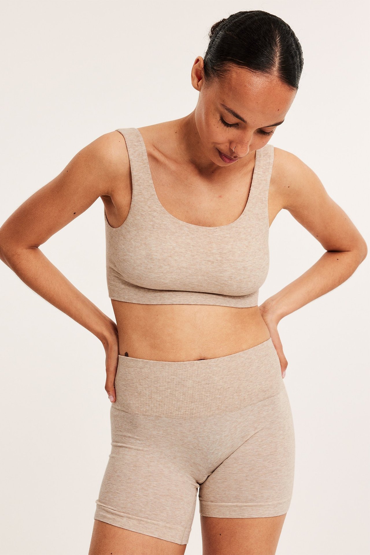 Frontbilde av en kvinne i beige melerte shortstruser i bomullsblanding og en matchende bralette.