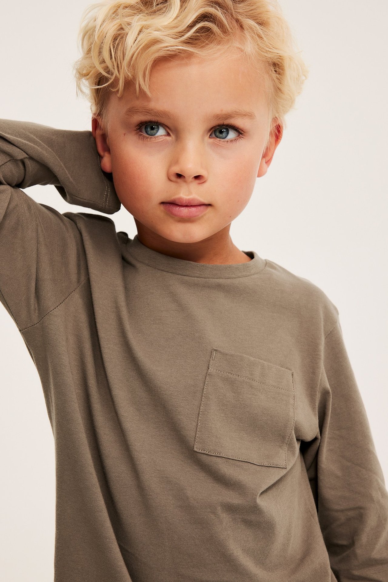 Pitkähihaiset ruskea puuvillainen T-paita, rintatasku, ribbihalko, etunäkymä, lapsi