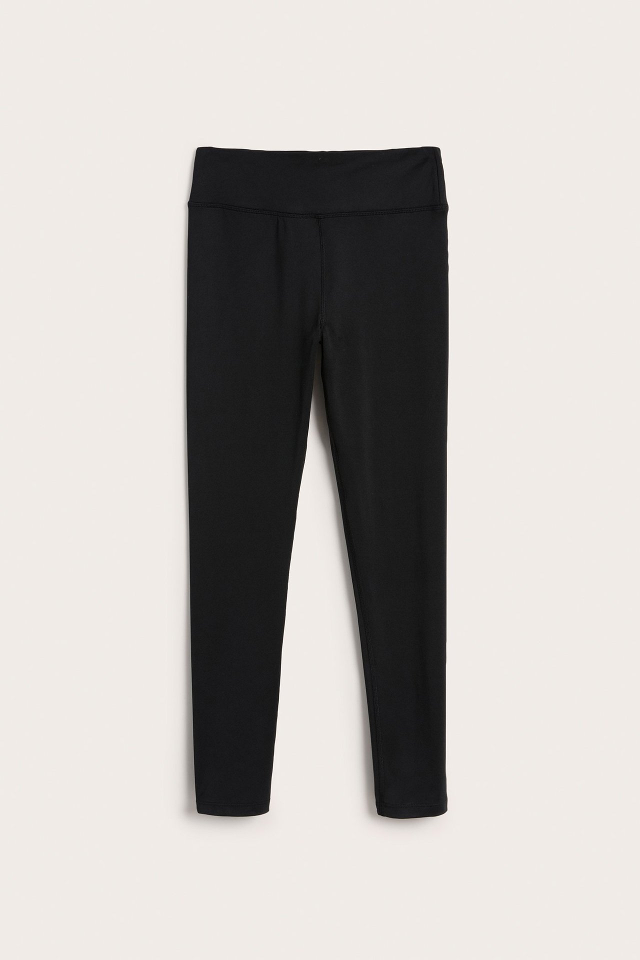 Edestä kuvatut mustat yksiväriset lasten urheiluleggingsit polyesteri-elastaanisekoitteesta.