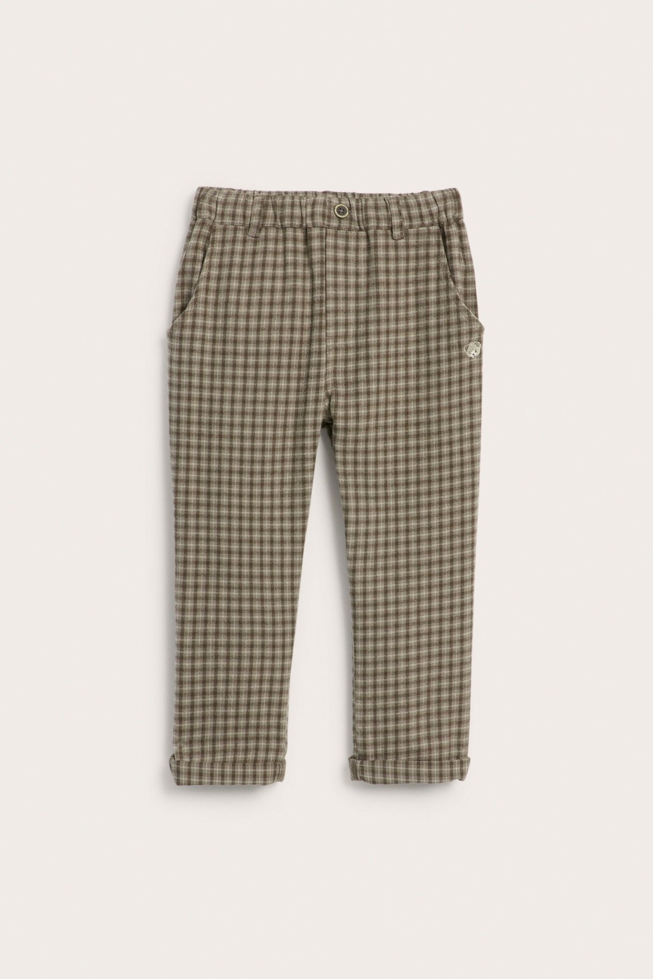 Frontvisning av barnebukser i brun- og beigerutete vevd twill, med elastisk midje og oppbrettede mansjetter.