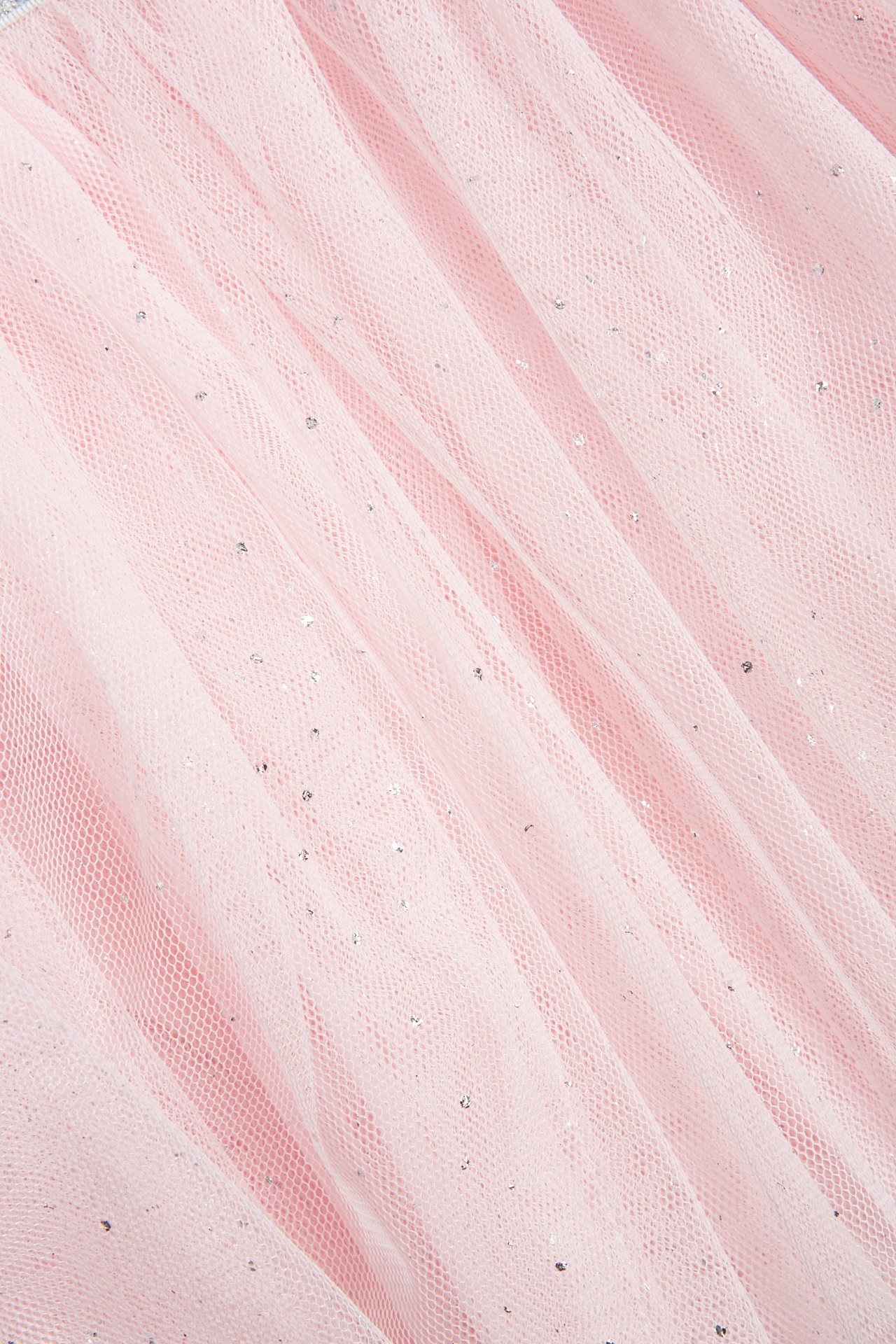 Zbliżenie jasnoróżowej tiulowej spódnicy sukienki do tańca ze srebrnym brokatem.