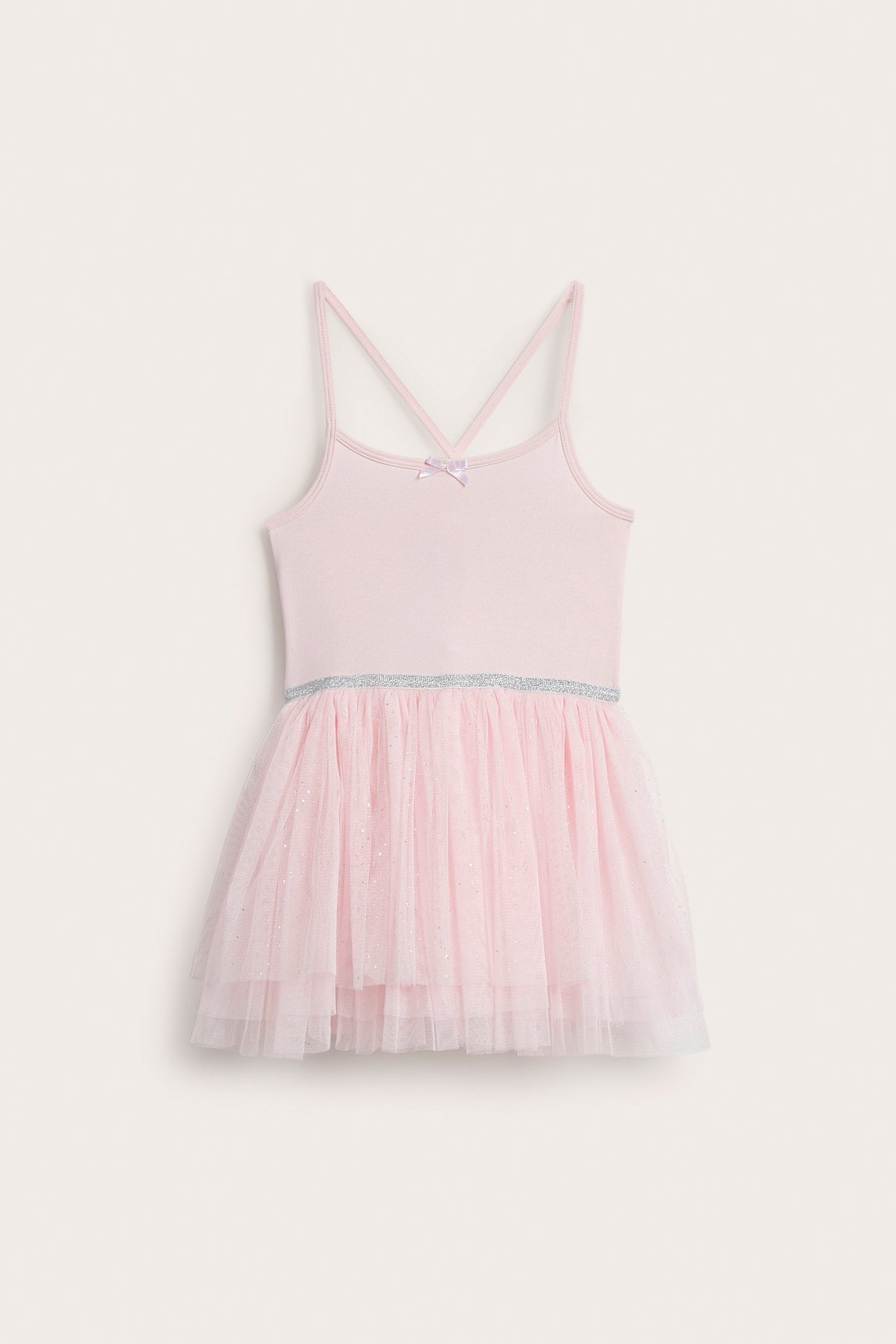 Widok z przodu: Jasnoróżowa sukienka taneczna dla dziecka ze skrzyżowanymi ramiączkami i tiulową spódnicą.