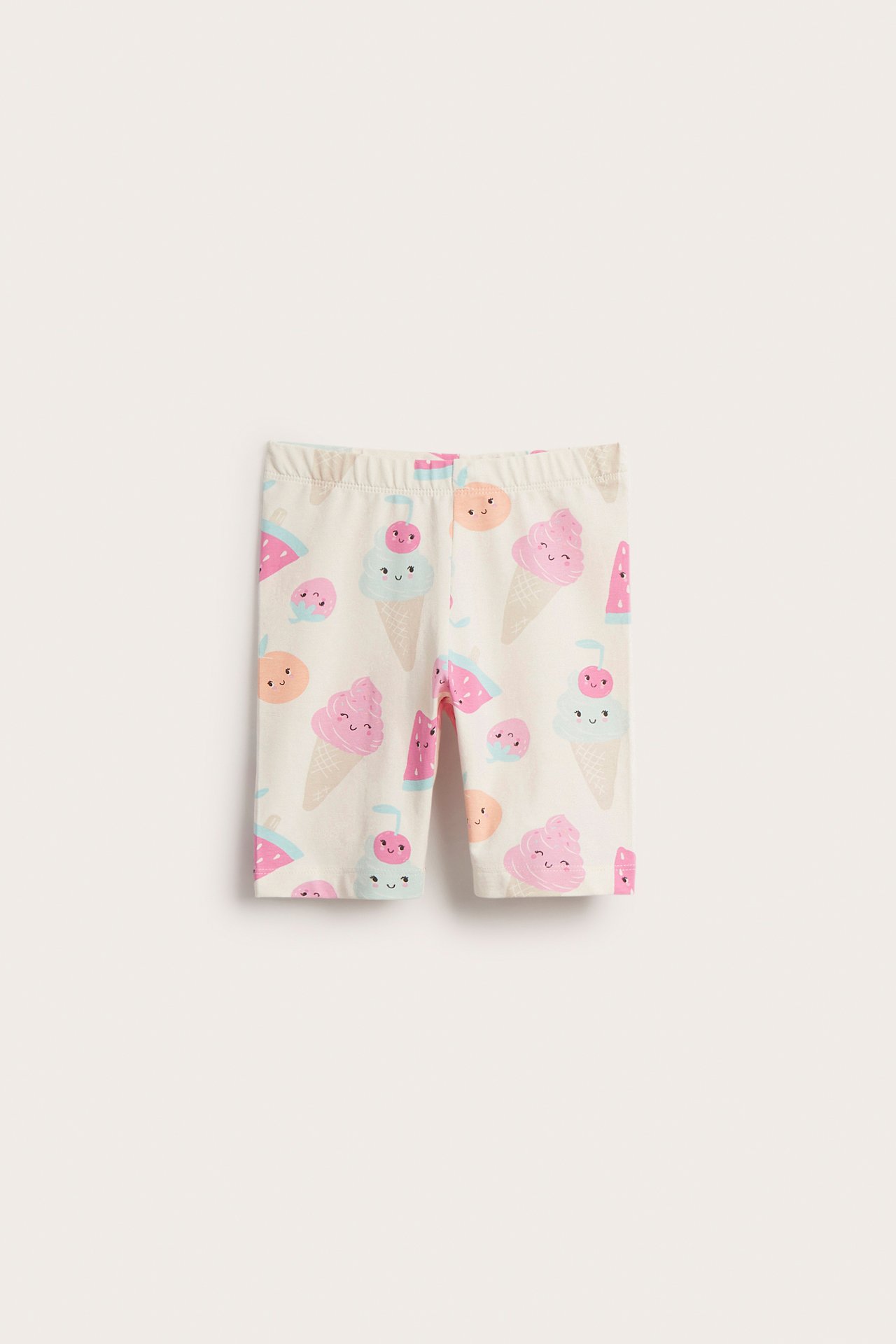 Frontvy av offwhite barncykelshorts med färgglatt glass- och fruktmönster.