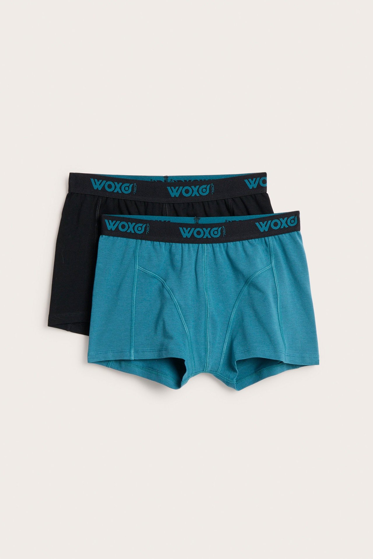 Widok z przodu dwóch par bokserek dziecięcych: jedne turkusowe, drugie czarne, z gumką WOXO.