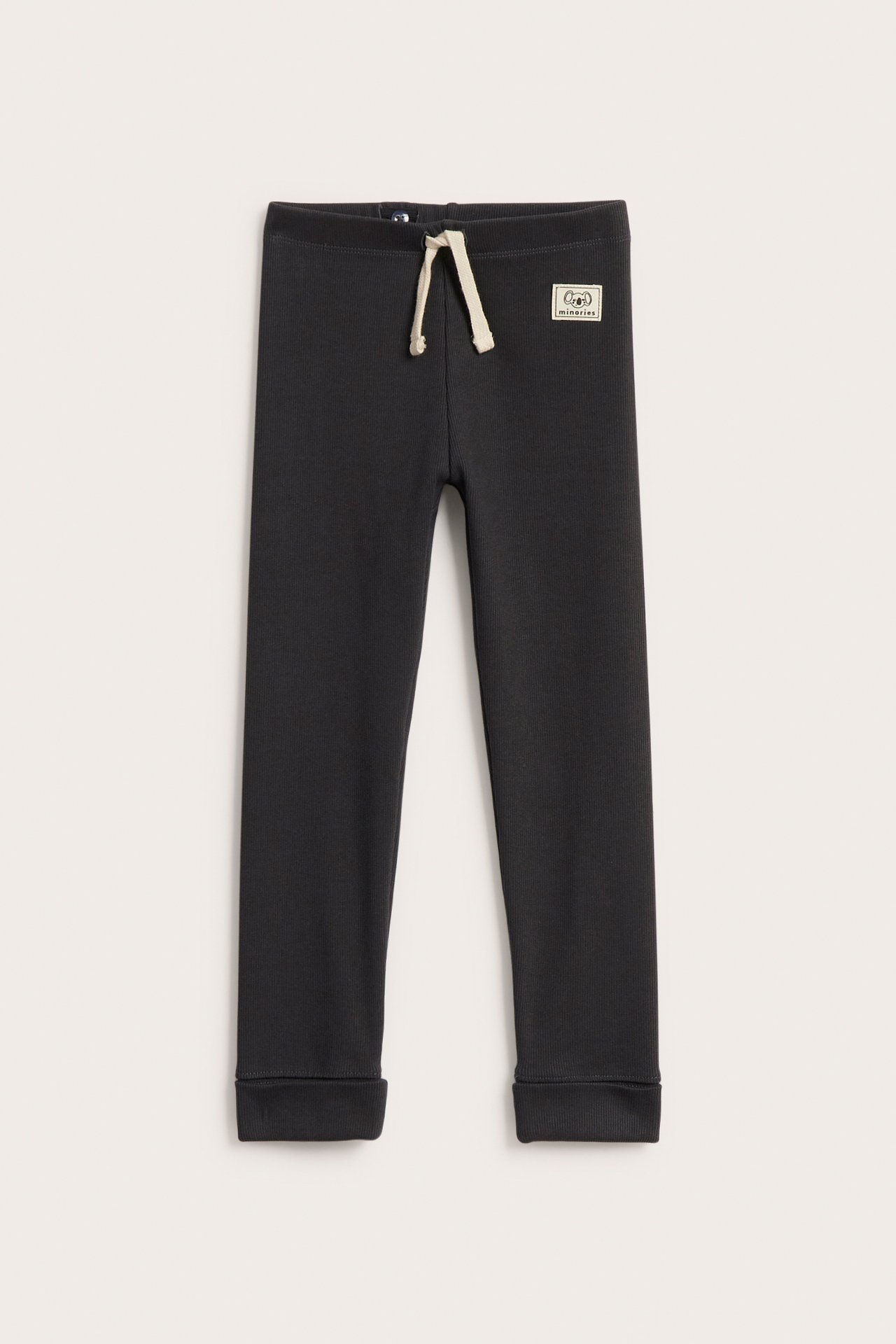 Framifrån svarta ribbade barnleggings med fuskdragsko i midjan och nedvikbara muddar.