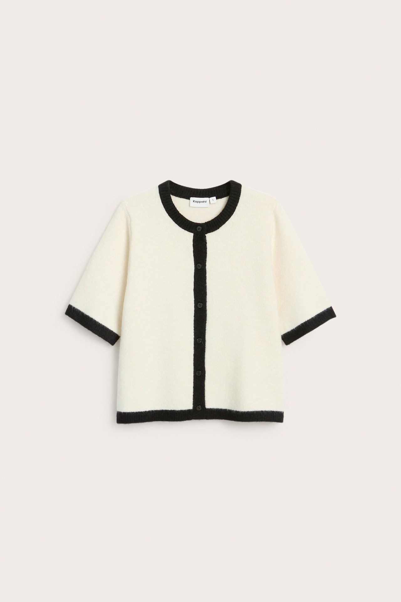 Frontvisning: Offwhite kortermet strikket cardigan med svart kant og svarte knapper.