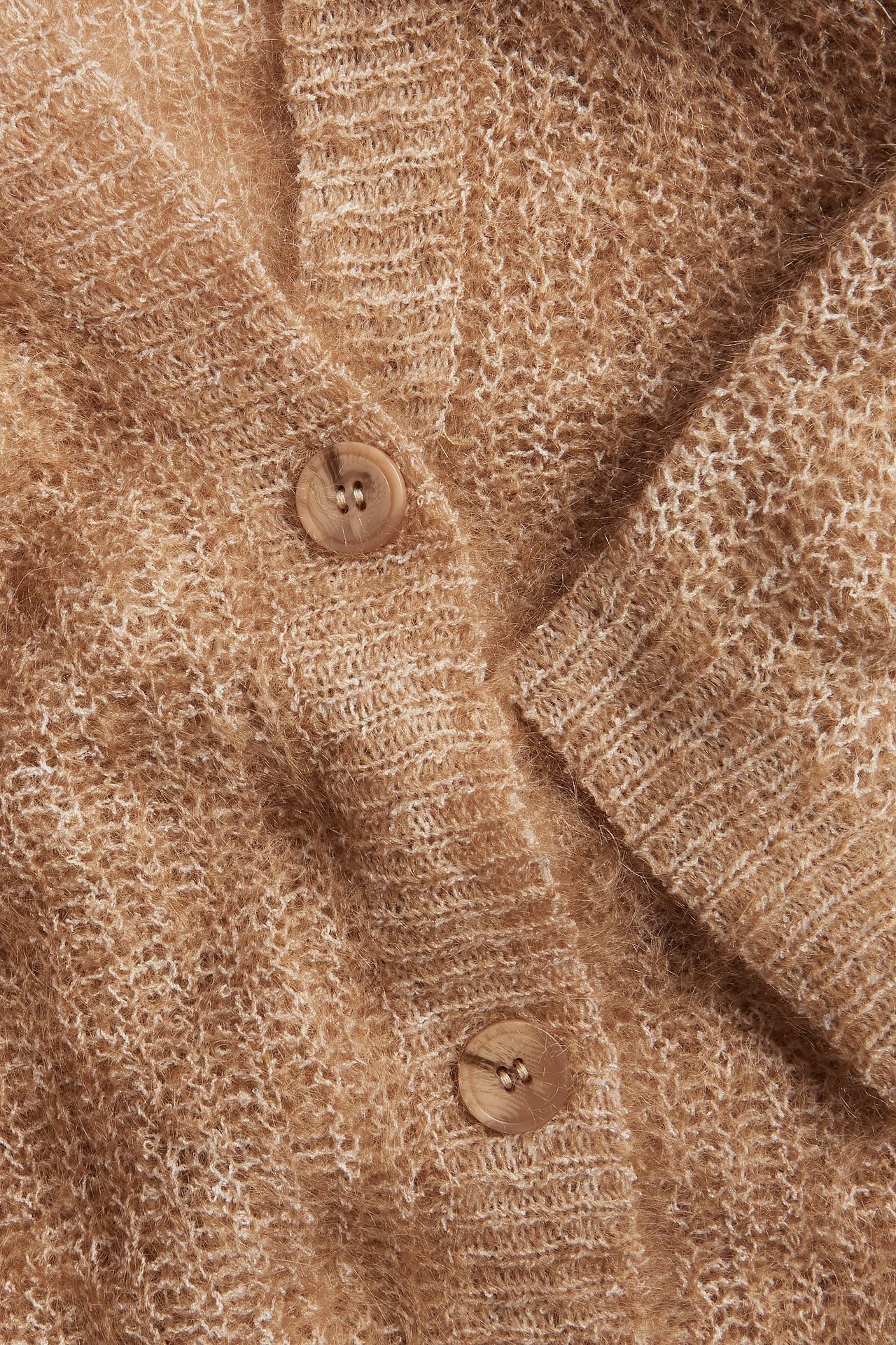 Zbliżenie brązowego kardiganu z mieszanki moheru z dwoma jasnobrązowymi guzikami i prążkowanymi detalami.