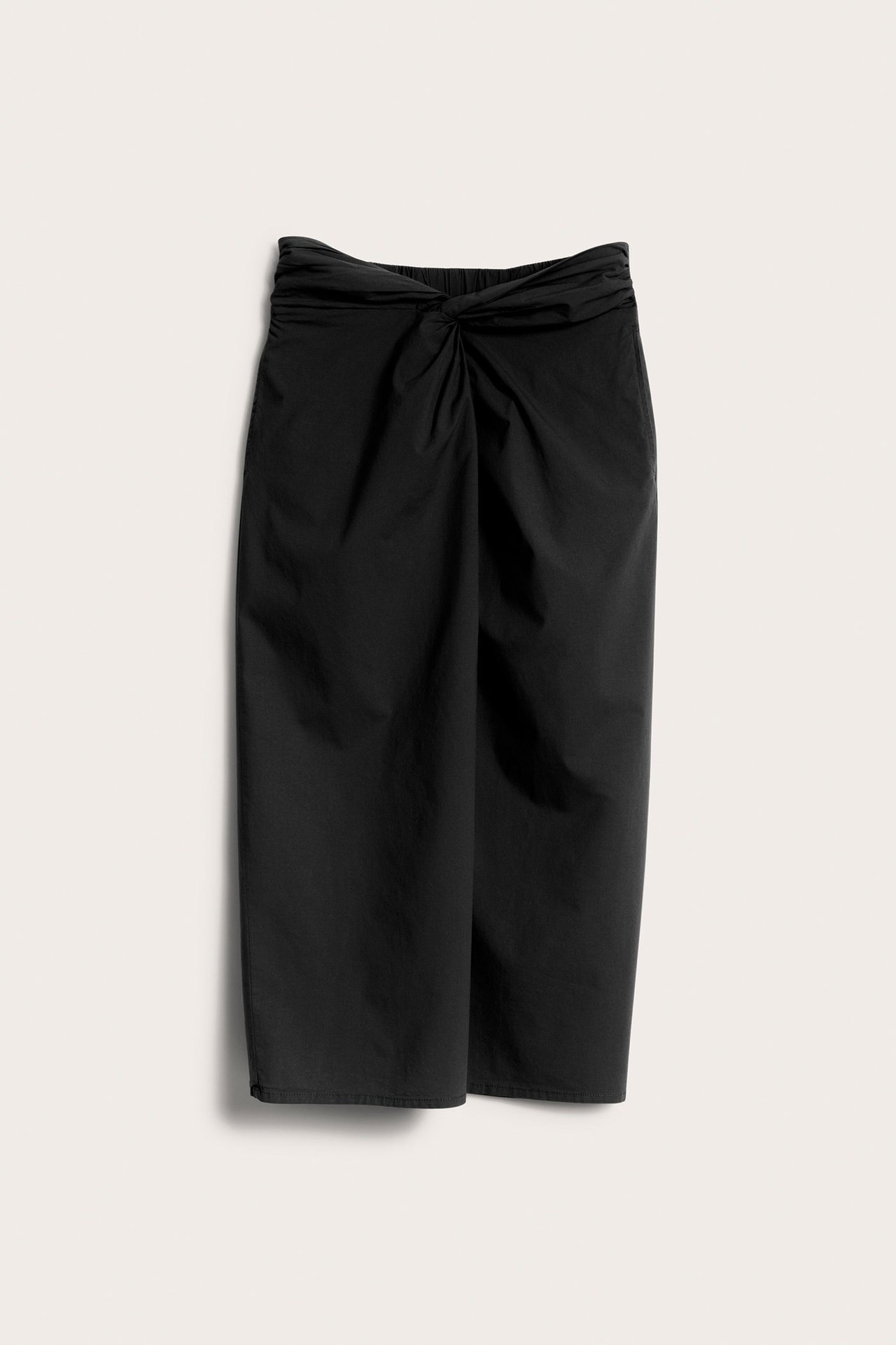 Frontvisning: svart midiskjørt i bomullsblanding med knutedetalj foran i midjen.