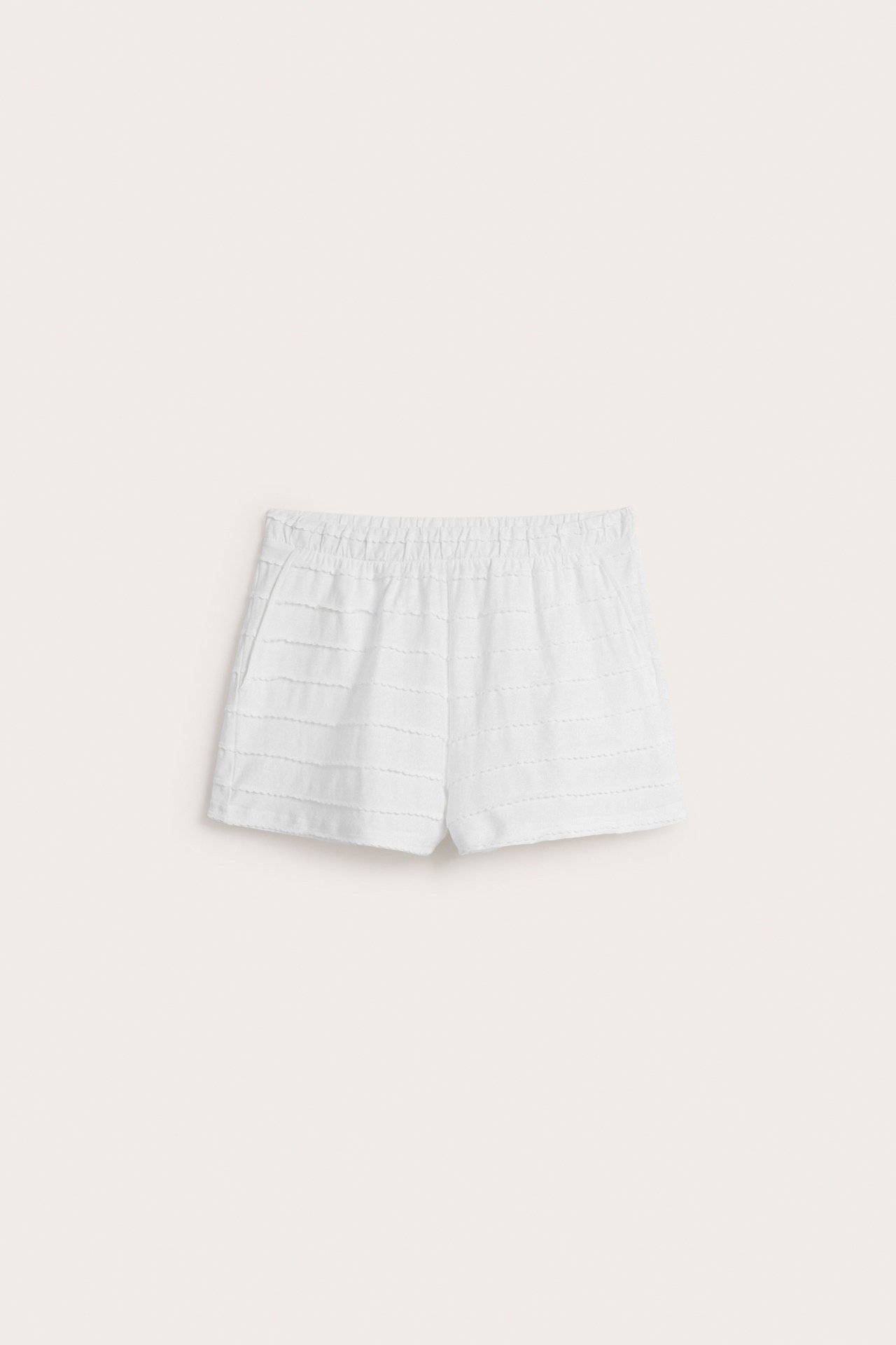 Forfra, offwhite bomullspysjamasshorts med elastisk midje og diskrete strukturstriper.