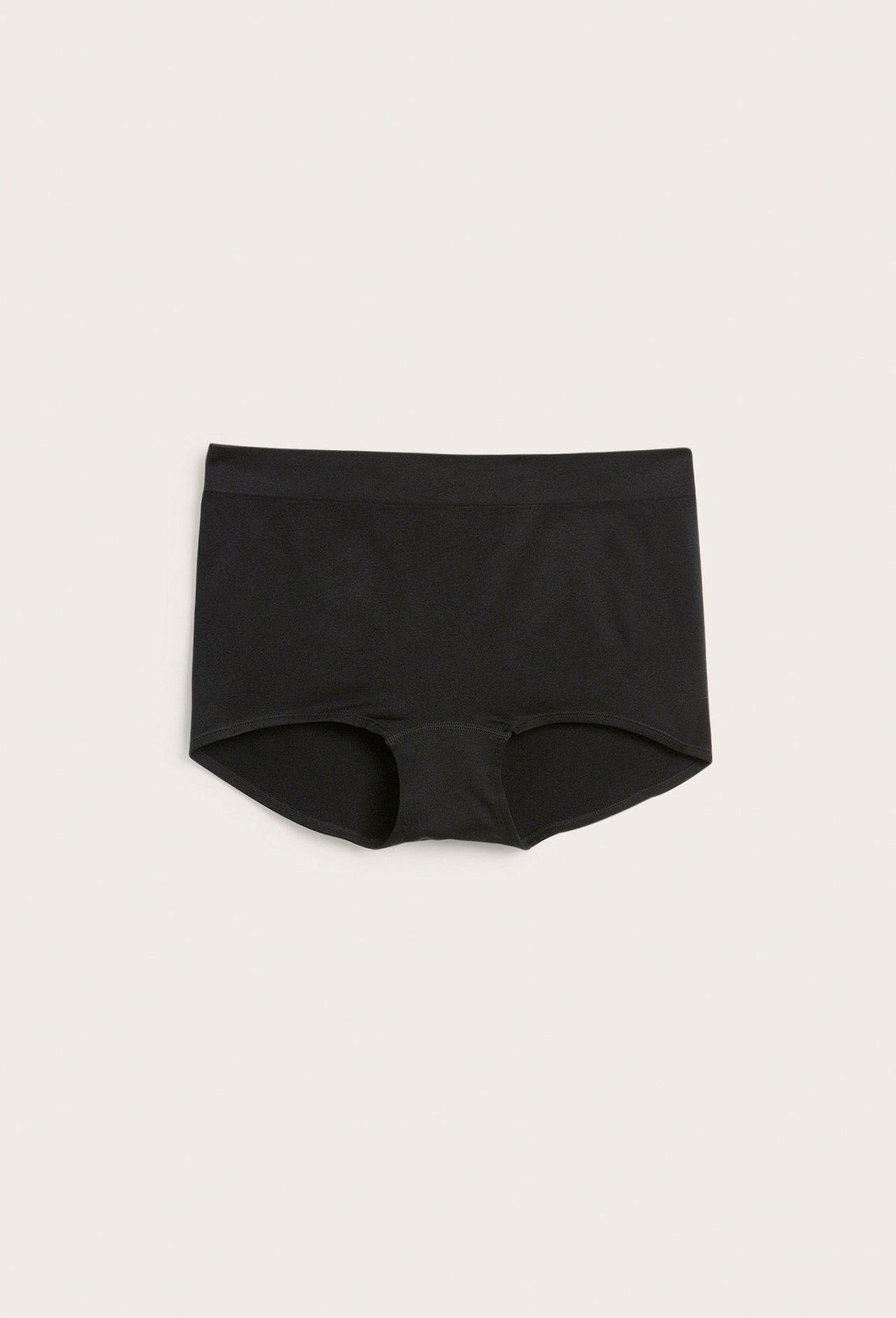 Frontvisning av en ensfarget svart sømløs boksertruse i glatt, elastisk stoff.