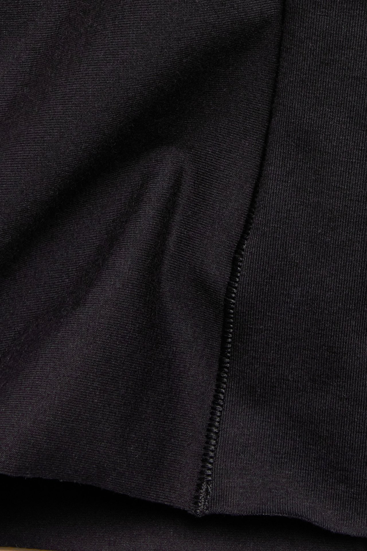 Zbliżenie na czarne szorty modelujące z mieszanki modalu, z widocznym szwem.