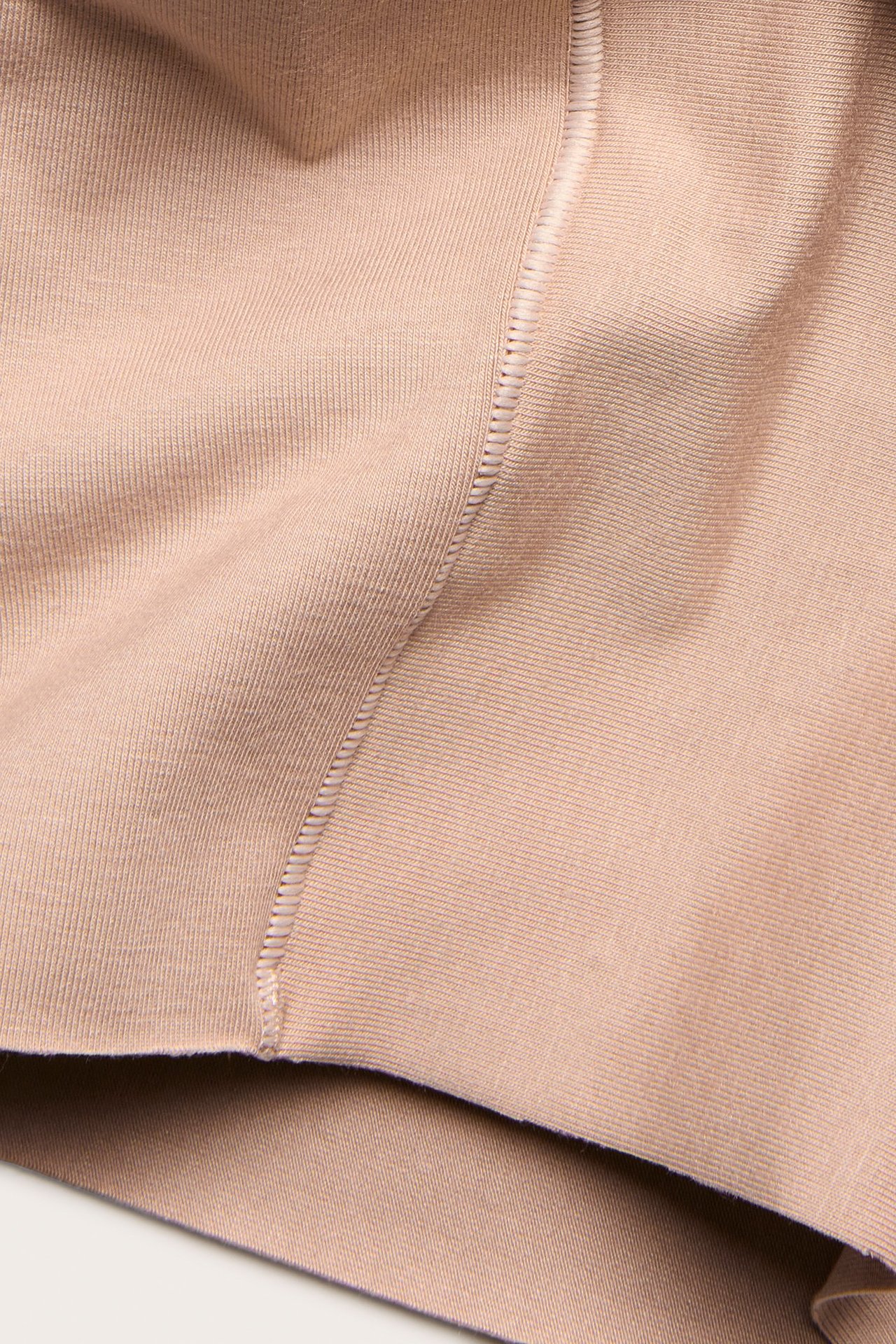 Zbliżenie na jasnobrązowe, jednolite szorty modelujące z mieszanki modalu z widocznym szwem.