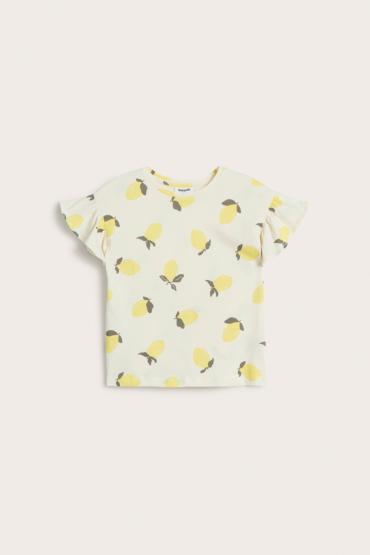 Frontvy av en offwhite barntopp i bomull med gult citronprint och volangärmar.