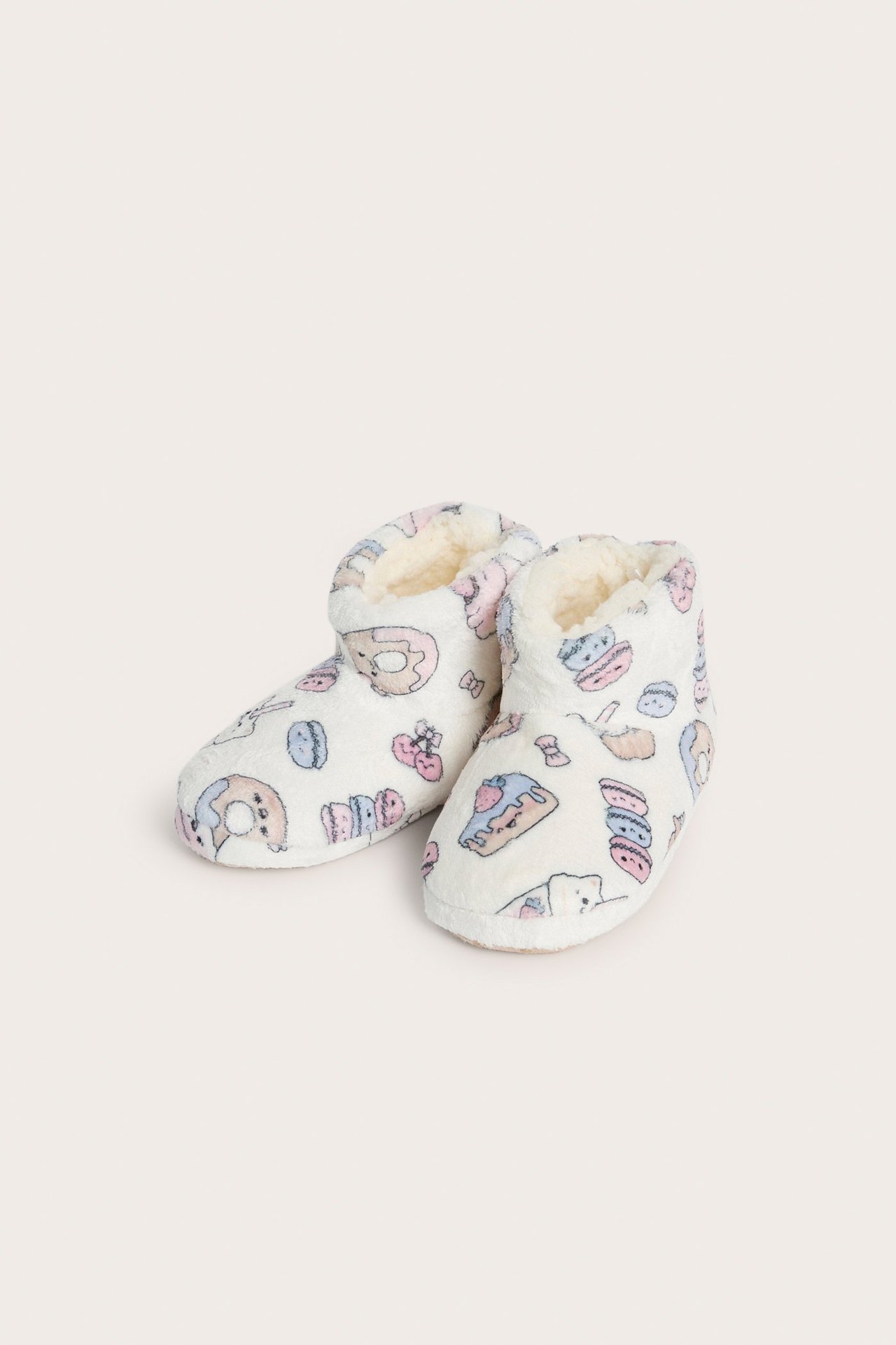 Edestä: Pehmeät luonnonvalkoiset tossut kakkupainatuksella ja pörröisellä vuorella.