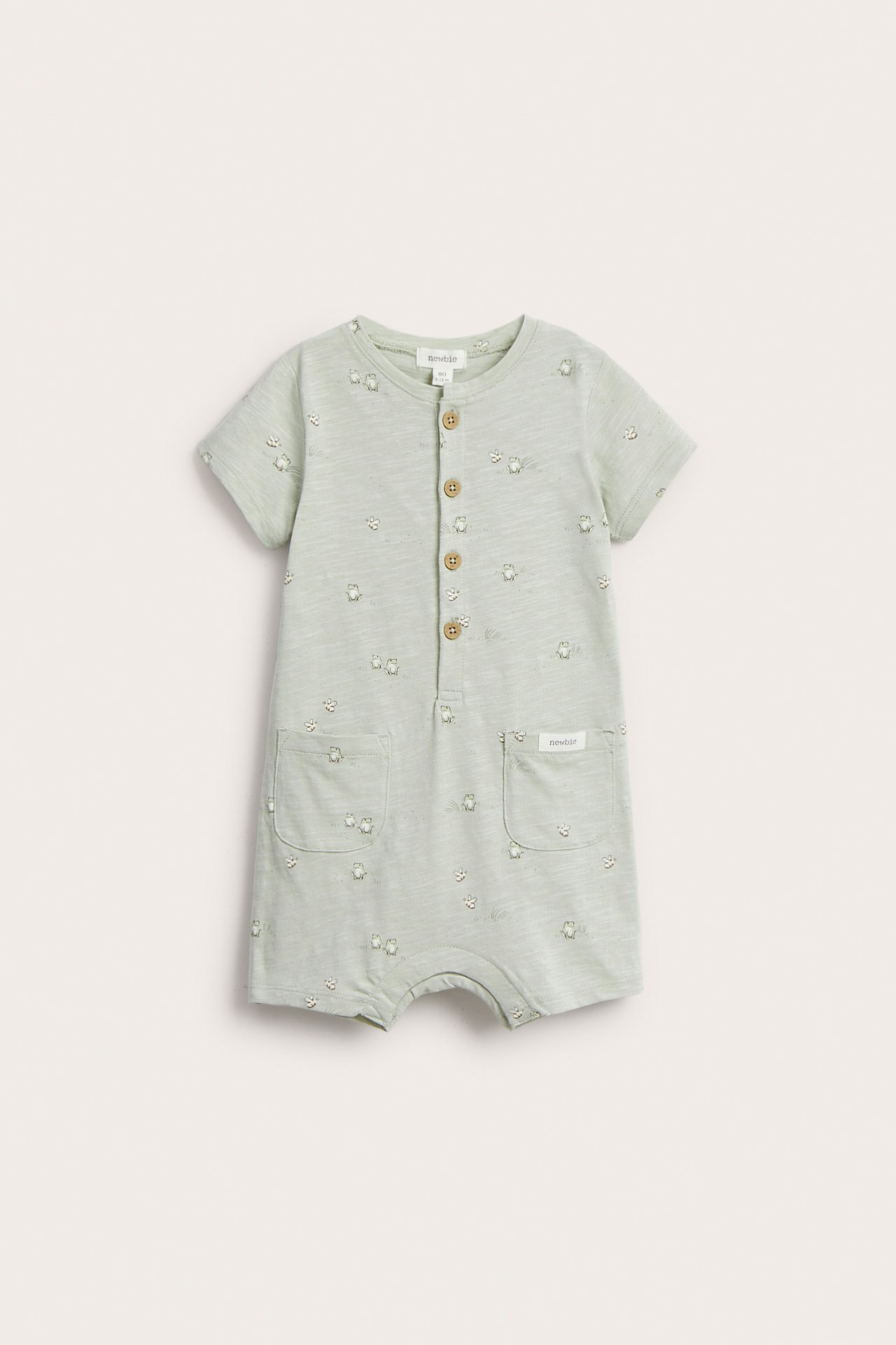 Framsida: Babyns ljusgröna bomulls-slub-playsuit med djurmönster, knappar fram och två fickor.