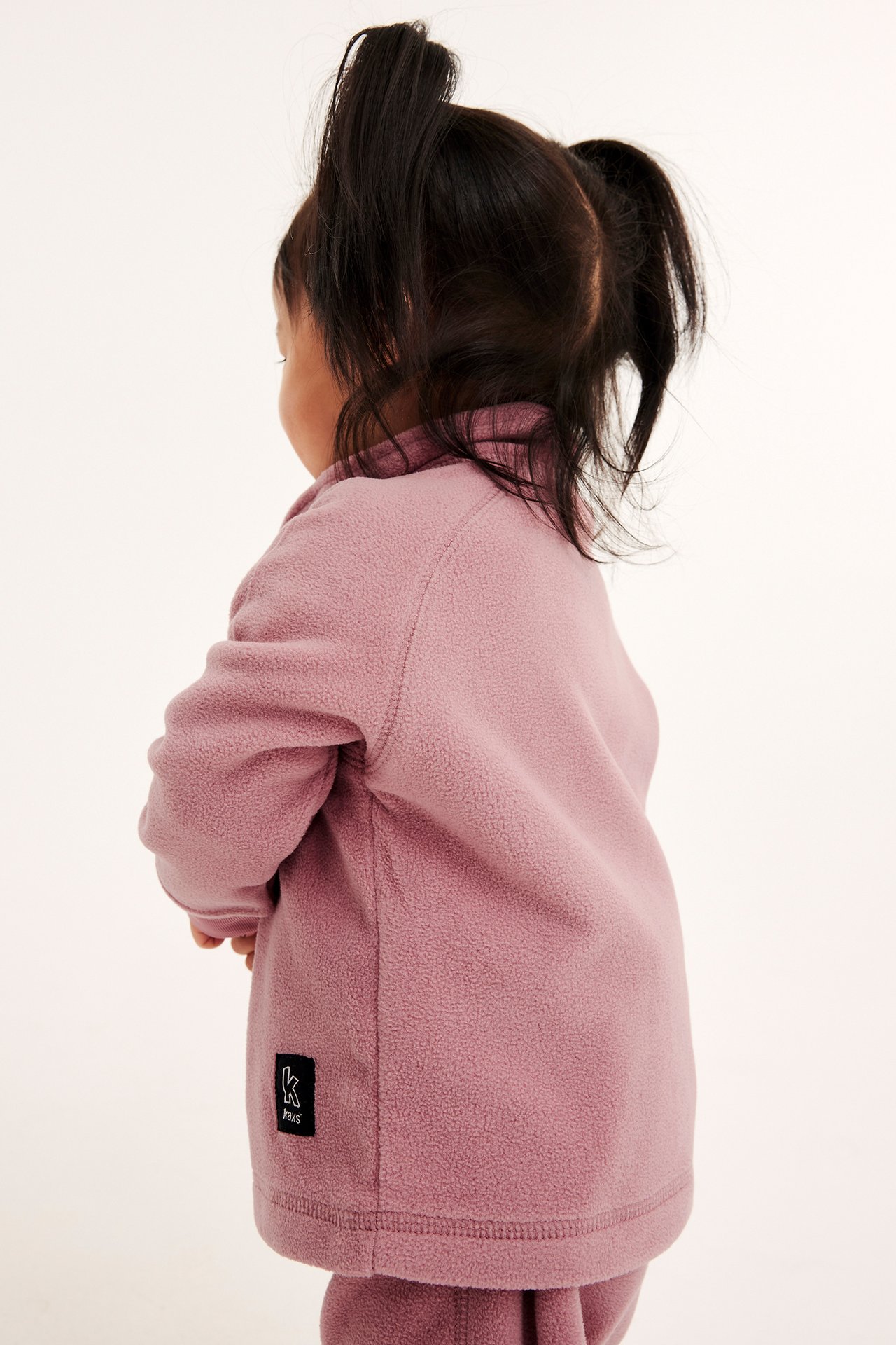 Barnfleecejacka i rosa fleece med zip-in / zip-off funktion, framförs i profil.