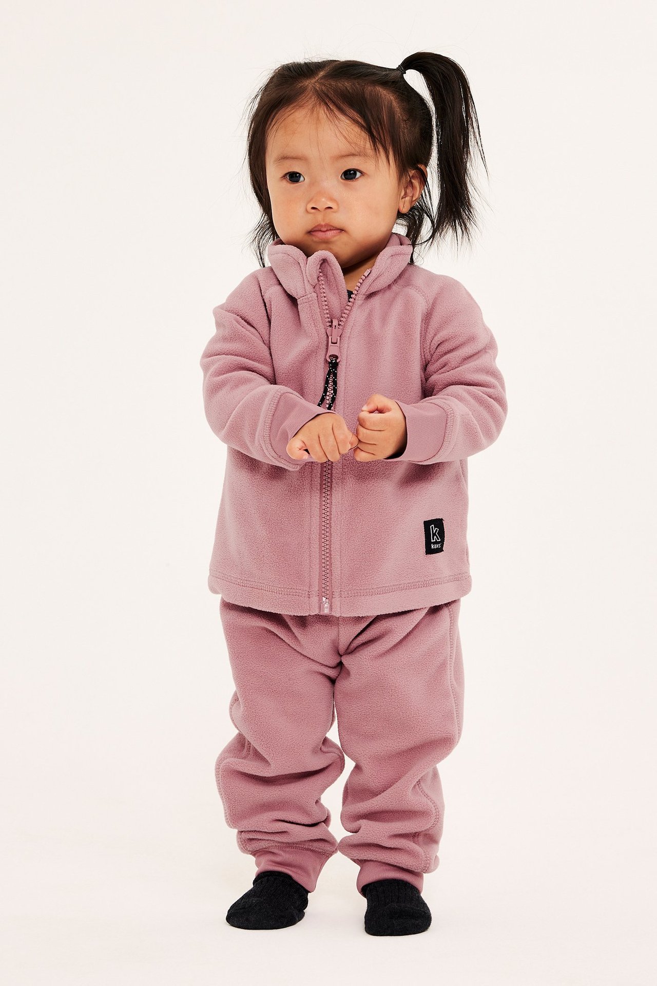 Pieni tyttö vaaleanpunaisissa fleecehousuissa, säädettävä vyötärö, resorit, etupuoli.